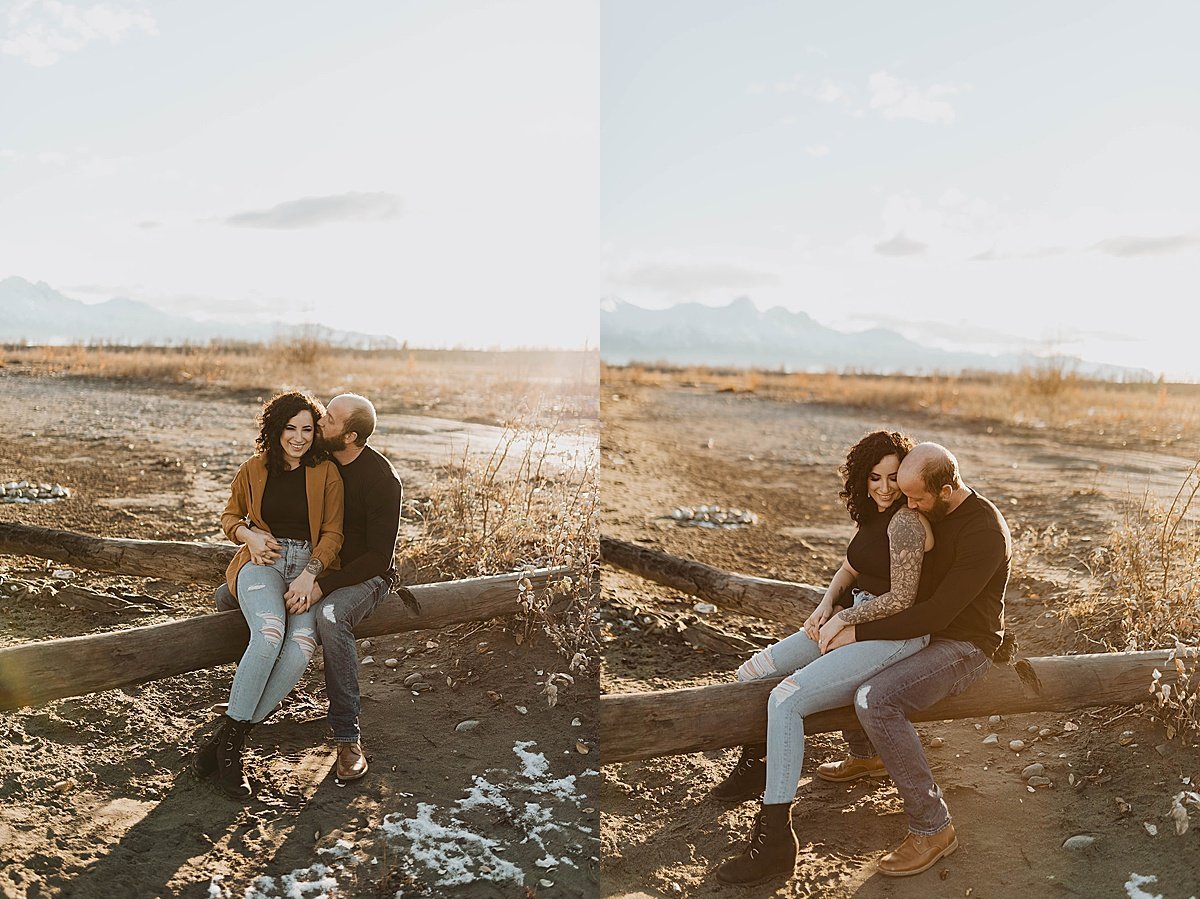  couple cuddles on rustic log during warm sunset engagement shoot in alaska 