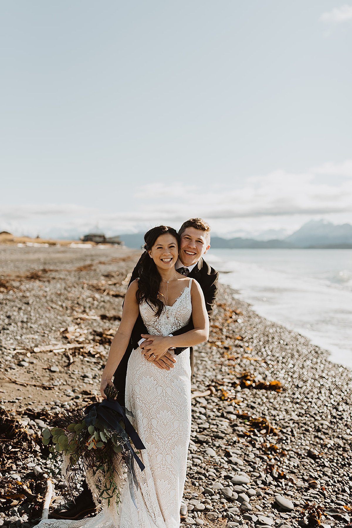  newlywed bride and groom pose on rocky beach after wedding ceremony shot by Theresa McDonald Photography 