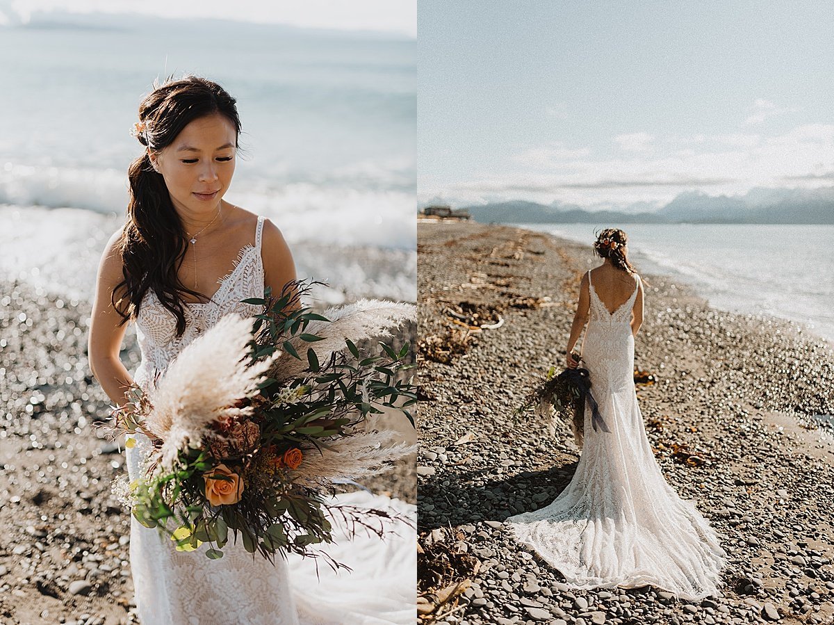  bride with autumn florals bouquet and white lace gown poses on rocky beach shot by alaska wedding photographer 