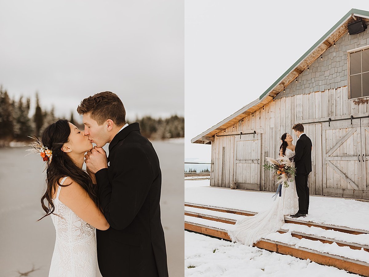  bride and groom kiss in front of rustic lakeside venue during snowy fall wedding 