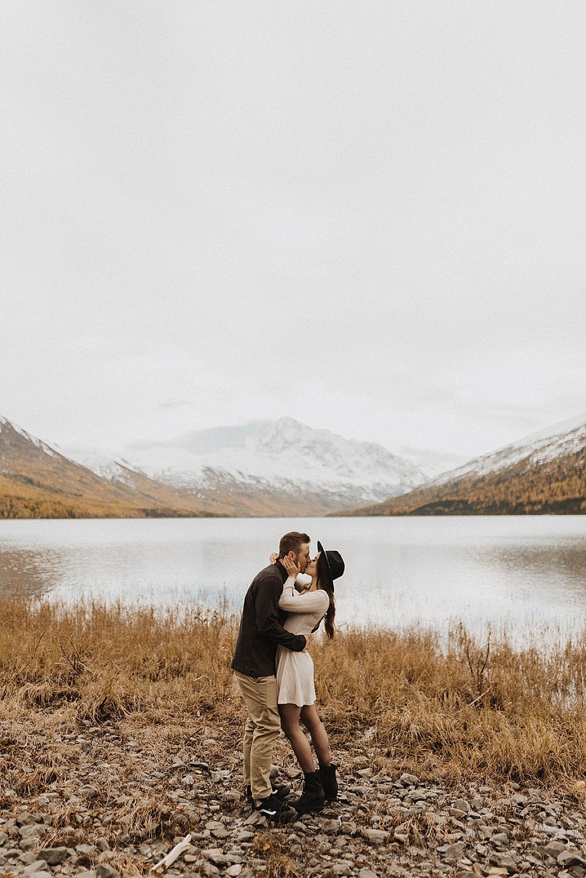  Engaged couple kiss at alaska mountain lake during autumn engagement shoot 
