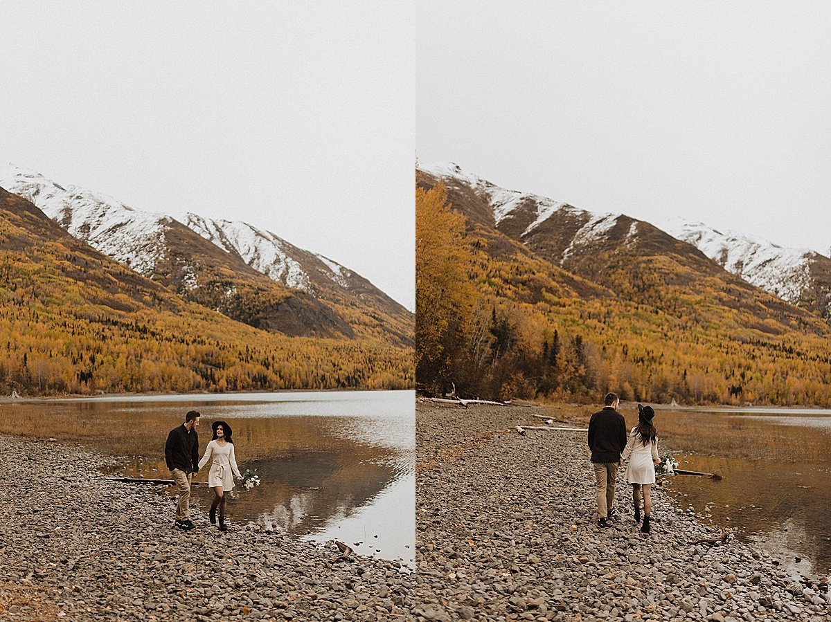 couple walk hand in hand on rocky mountain lake beach in alaska engagement shoot by theresa mcdonald photography 