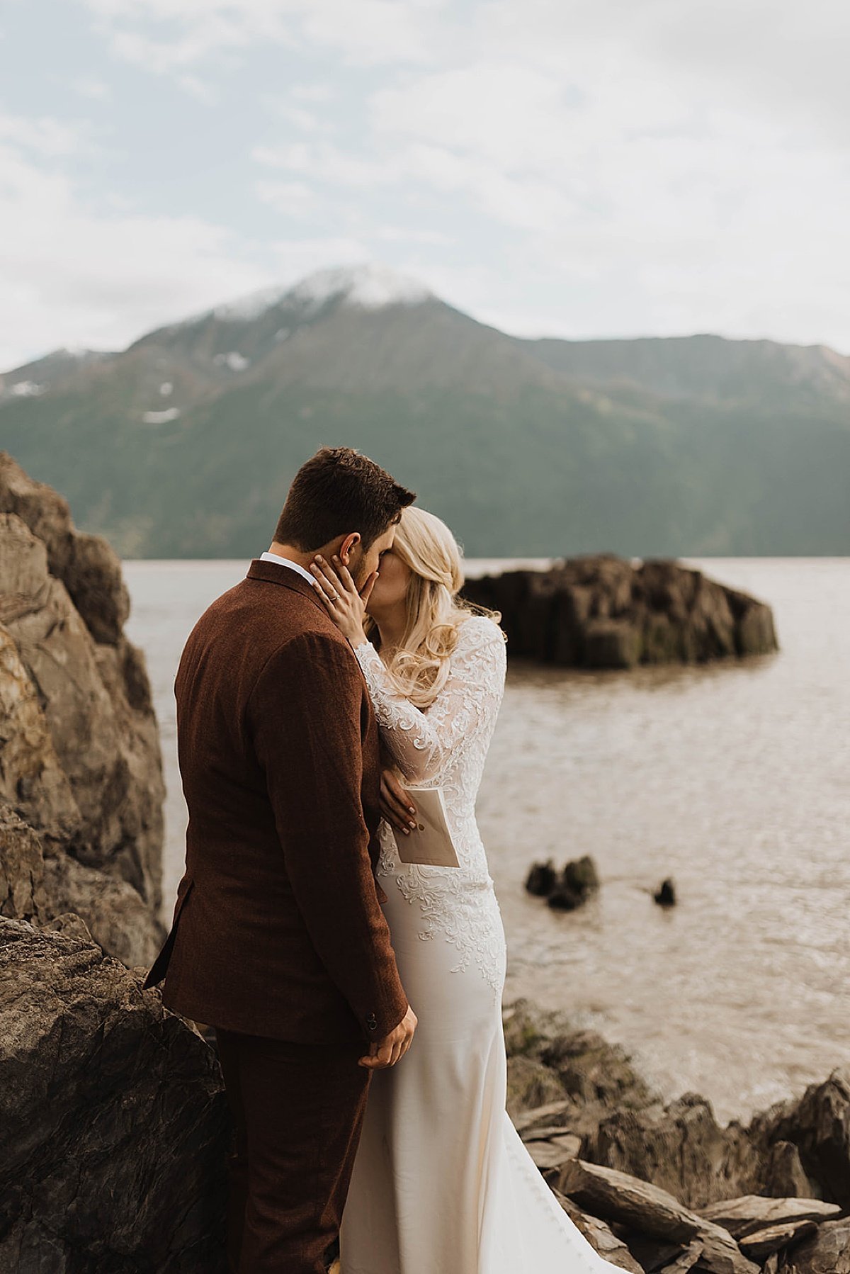 newlywed bride and groom kiss at mountain lake in moody glacier creek wedding 