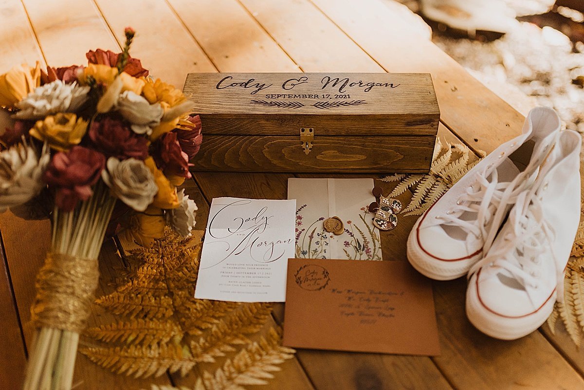  closeup detail of wedding bouquet, stationary, and bride’s sneakers before alaska ceremony shot by theresa mcdonald 