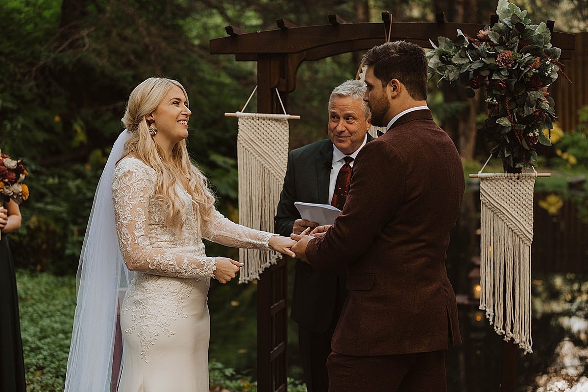  bride and groom share vows at forest wedding with dreamcatchers in the background, shot by theresa mcdonald 