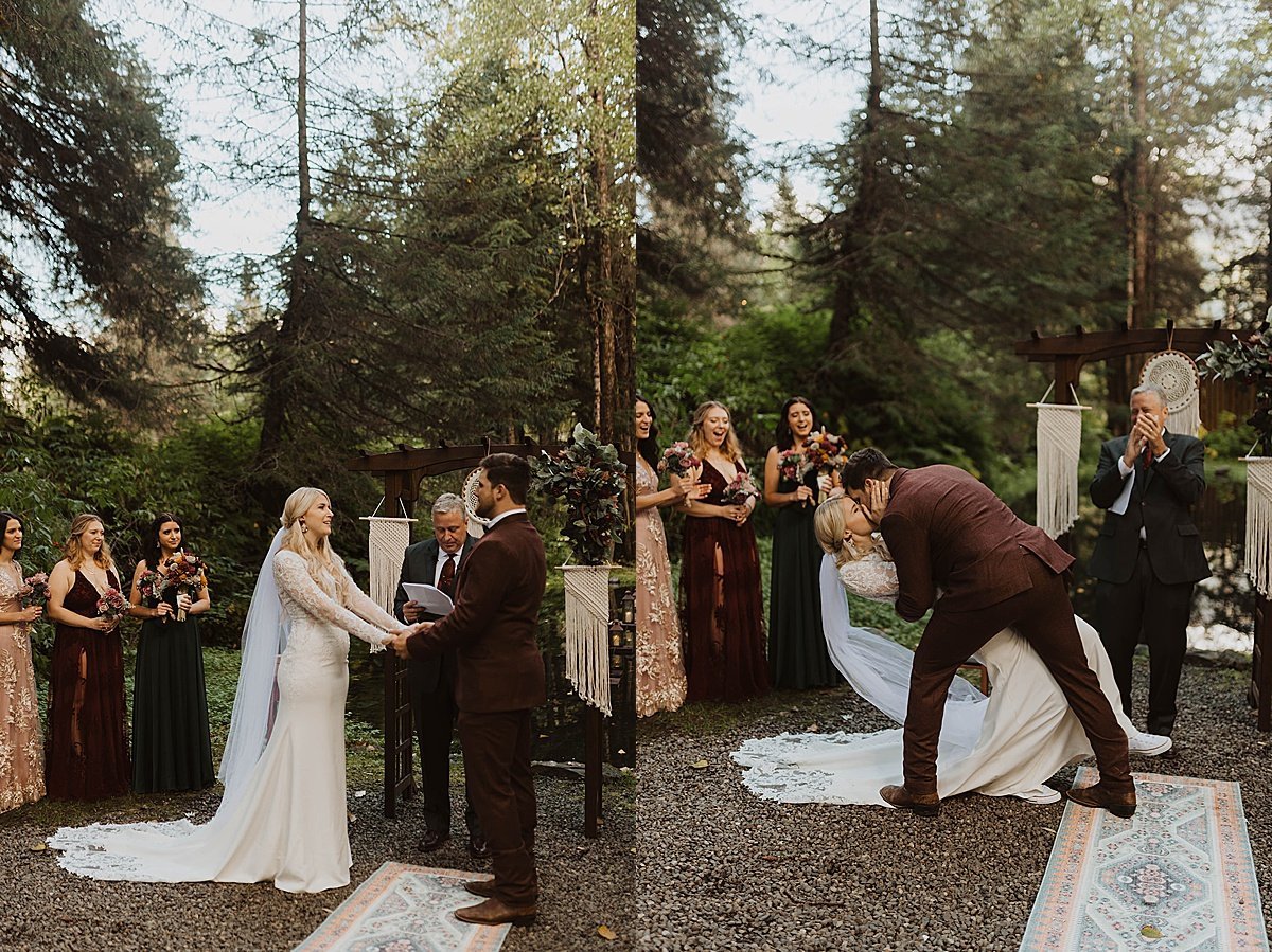  bride and groom share vows and kiss at outdoor ceremony while bridesmaids in jewel toned dresses smile during moody glacier creek wedding 