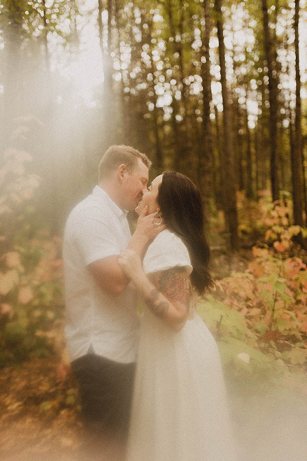  Couple kiss in golden fall leaves engagement shoot in alaska 