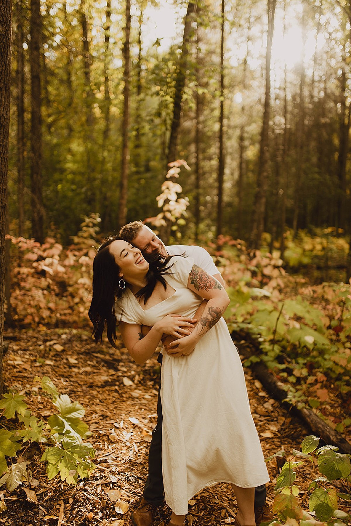  Man and woman playfully hug in woodsy engagement shoot by alaska wedding photographer Theresa McDonald 
