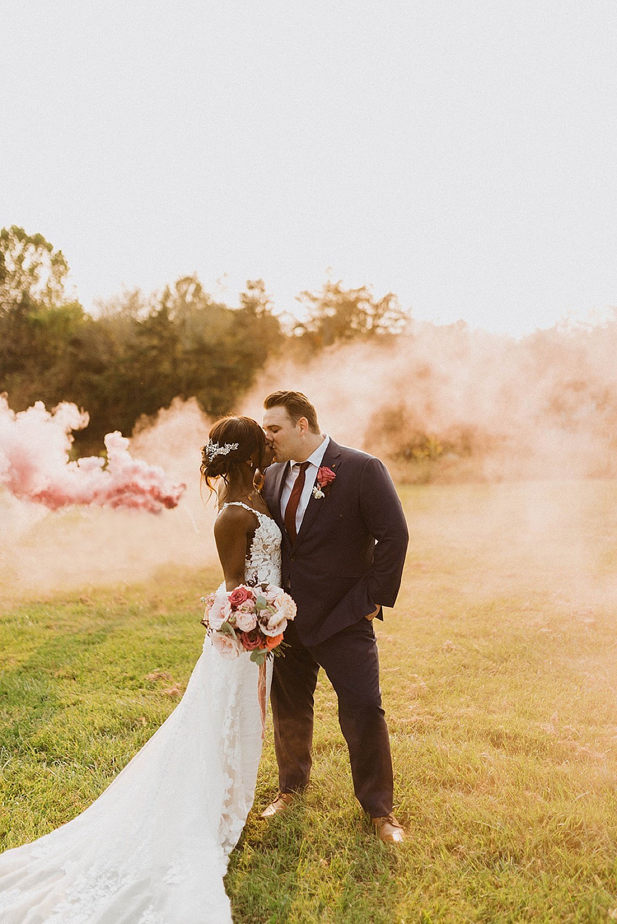  Bride and groom kiss surrounded by colorful smoke in outdoor wedding shot by Theresa mcdonald 