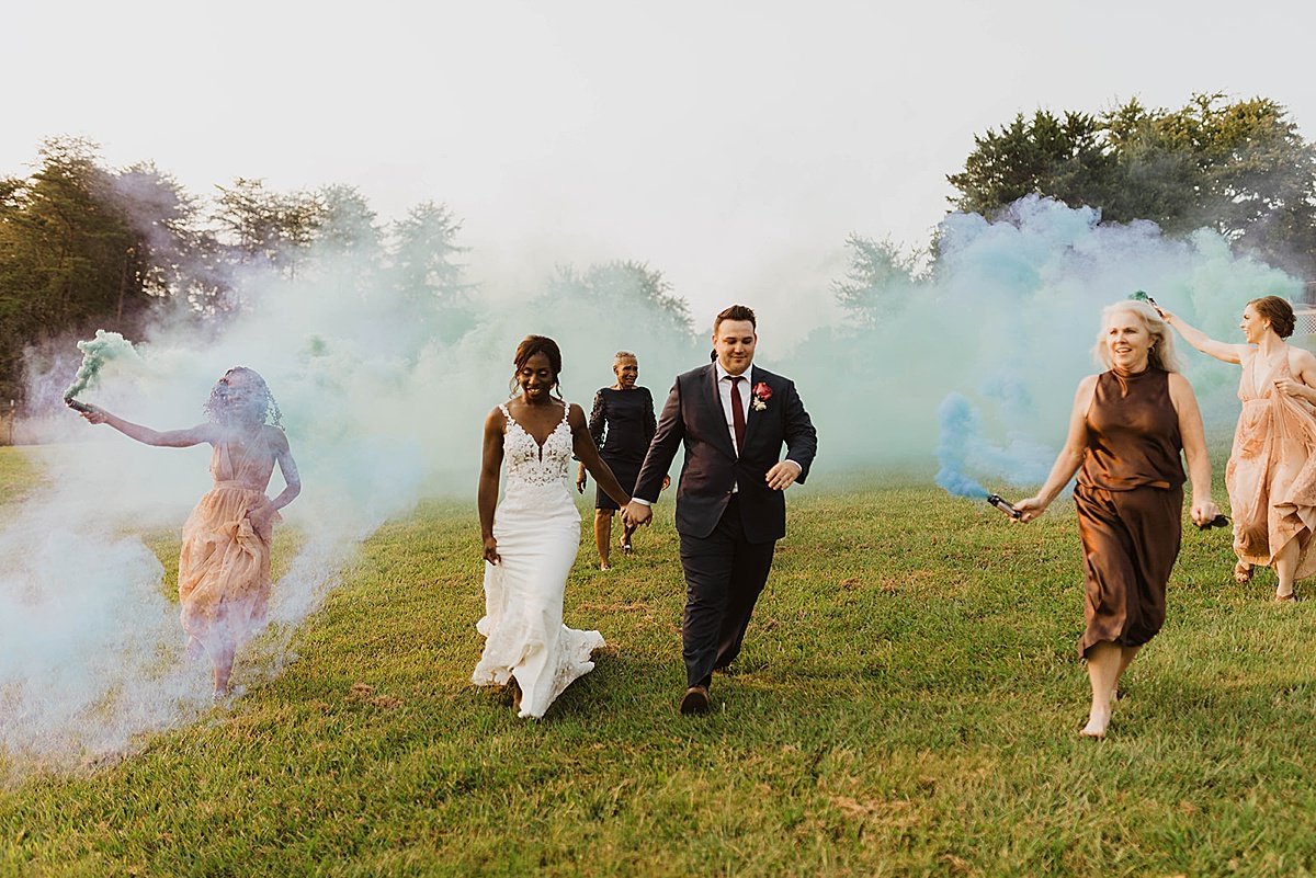 Bride and groom walk through colorful smoke at Tennessee wedding 