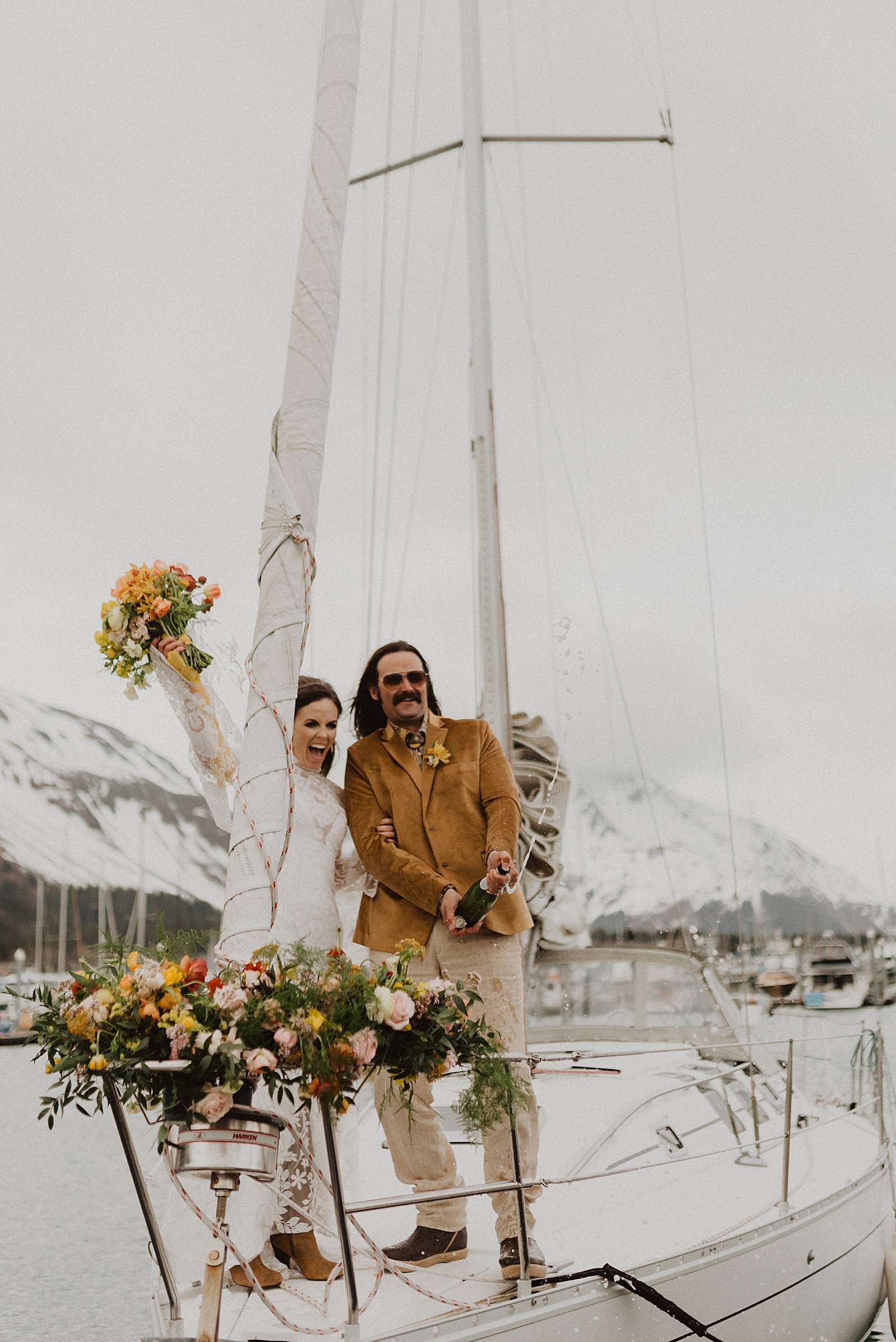  Bride and groom popping champagne on a boat celebrating in Alaska 