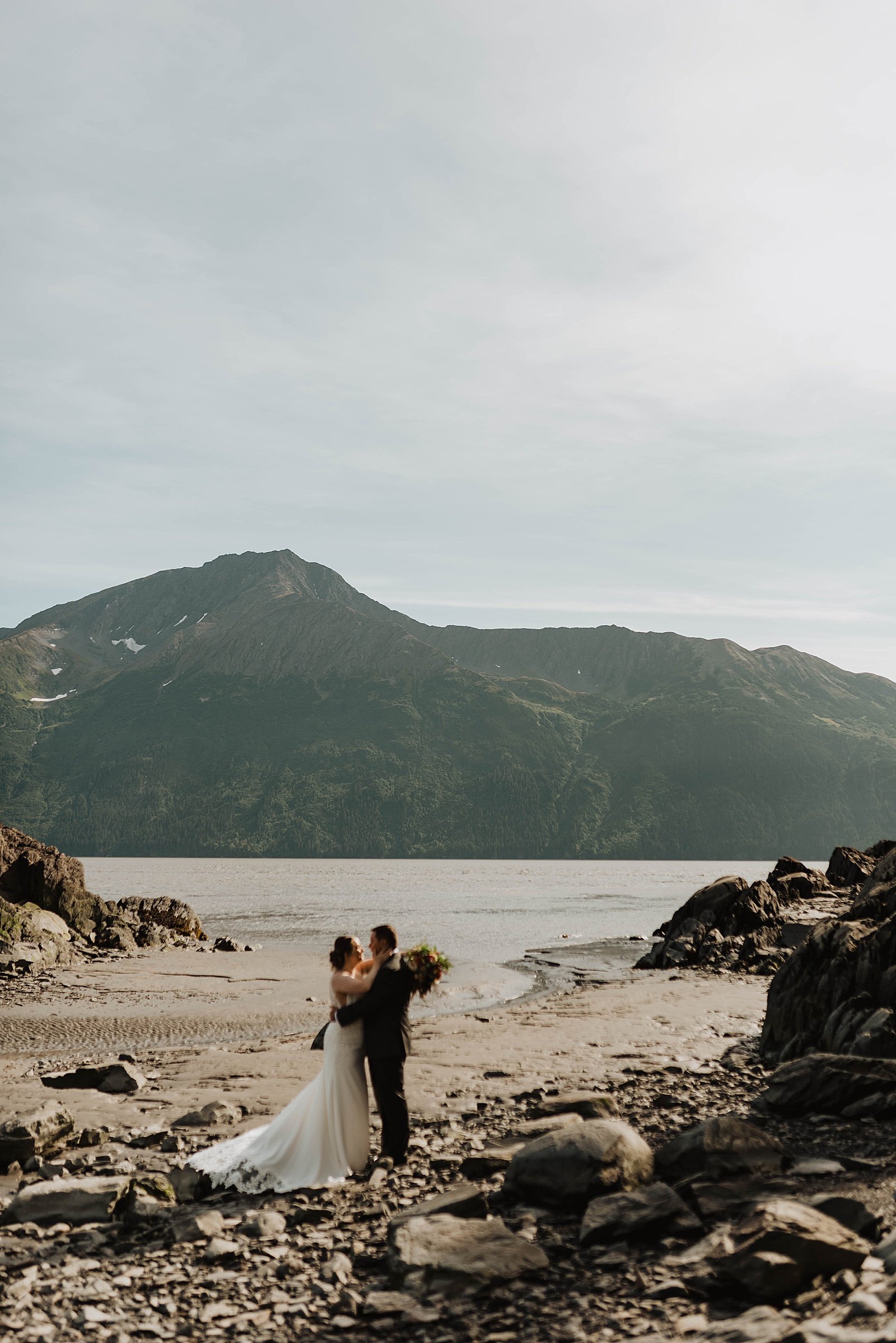  Bride in groom with mountains behind them for Girdwood intimate family elopement 