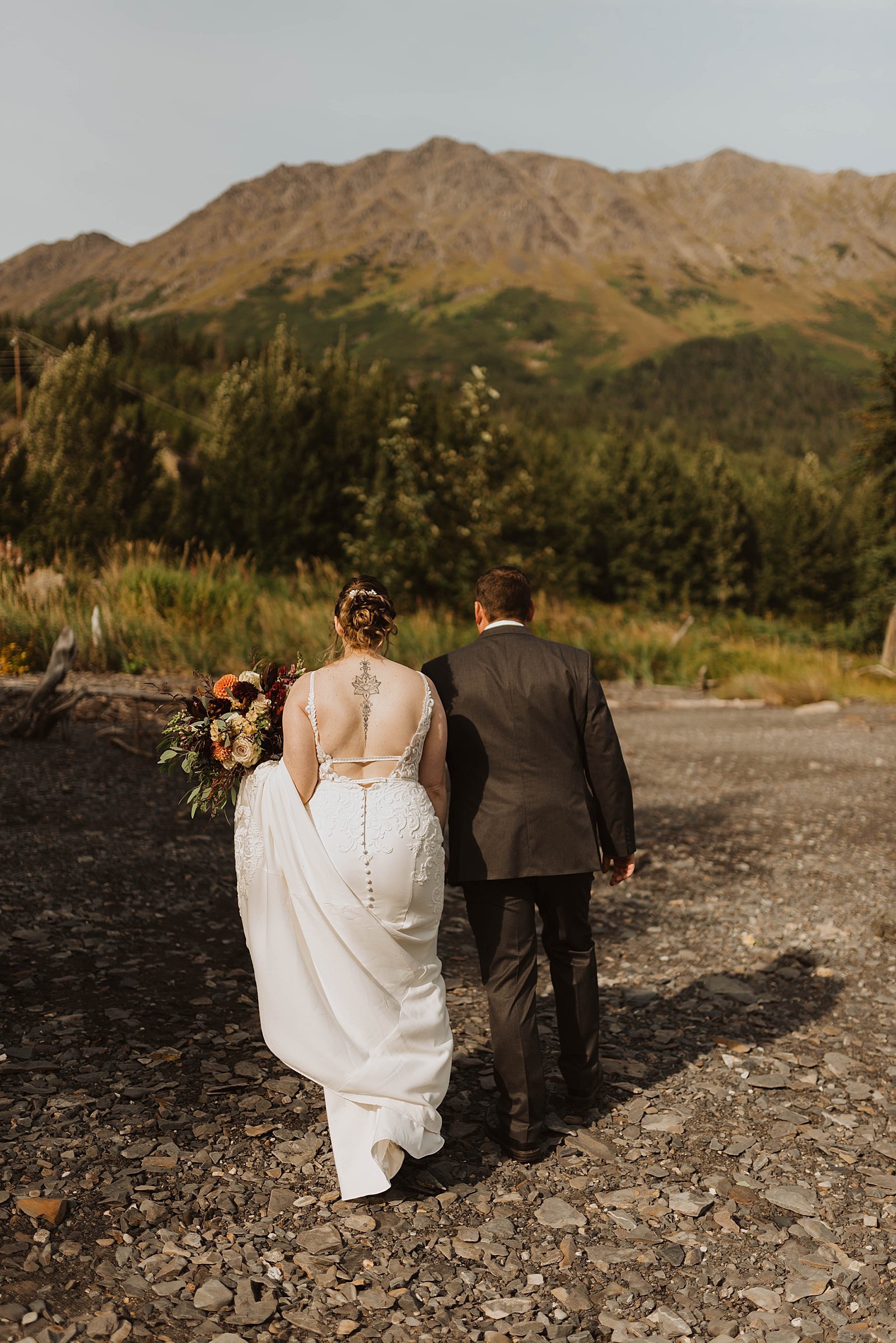 Adventurous bride and groom walking together after private ceremony  