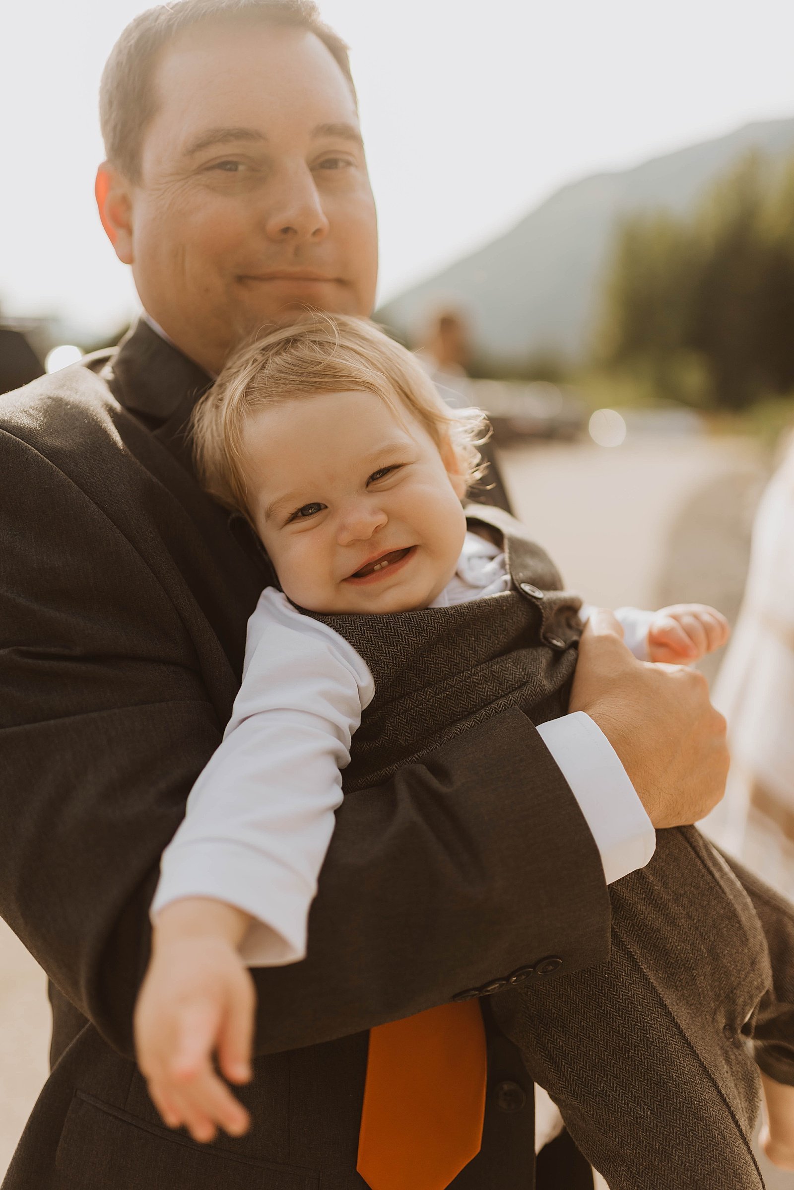  Groom carrying his baby son after intimate elopement  