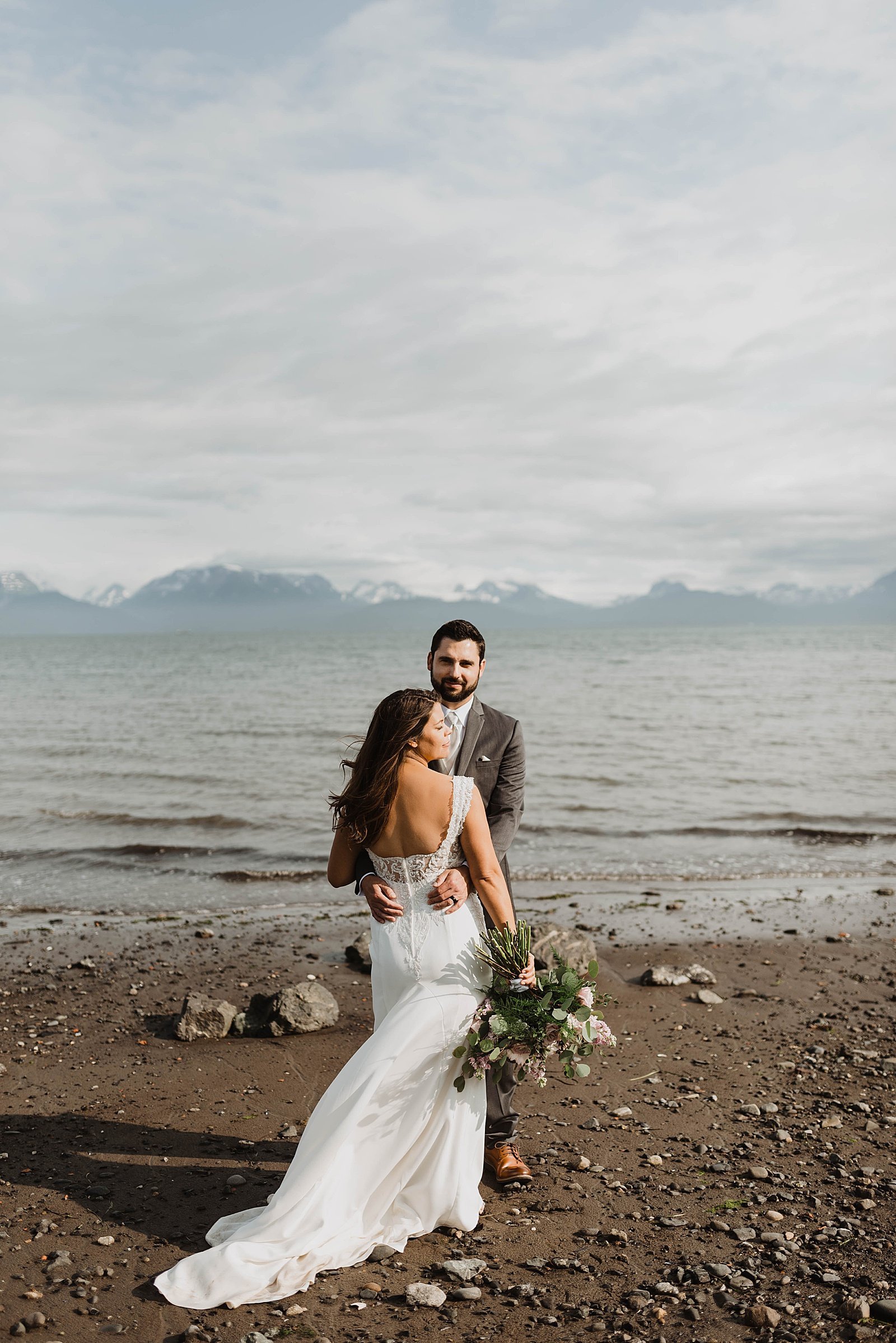  Bride and groom with water and mountains behind them by Alaska Wedding Photographer, Theresa McDonald 