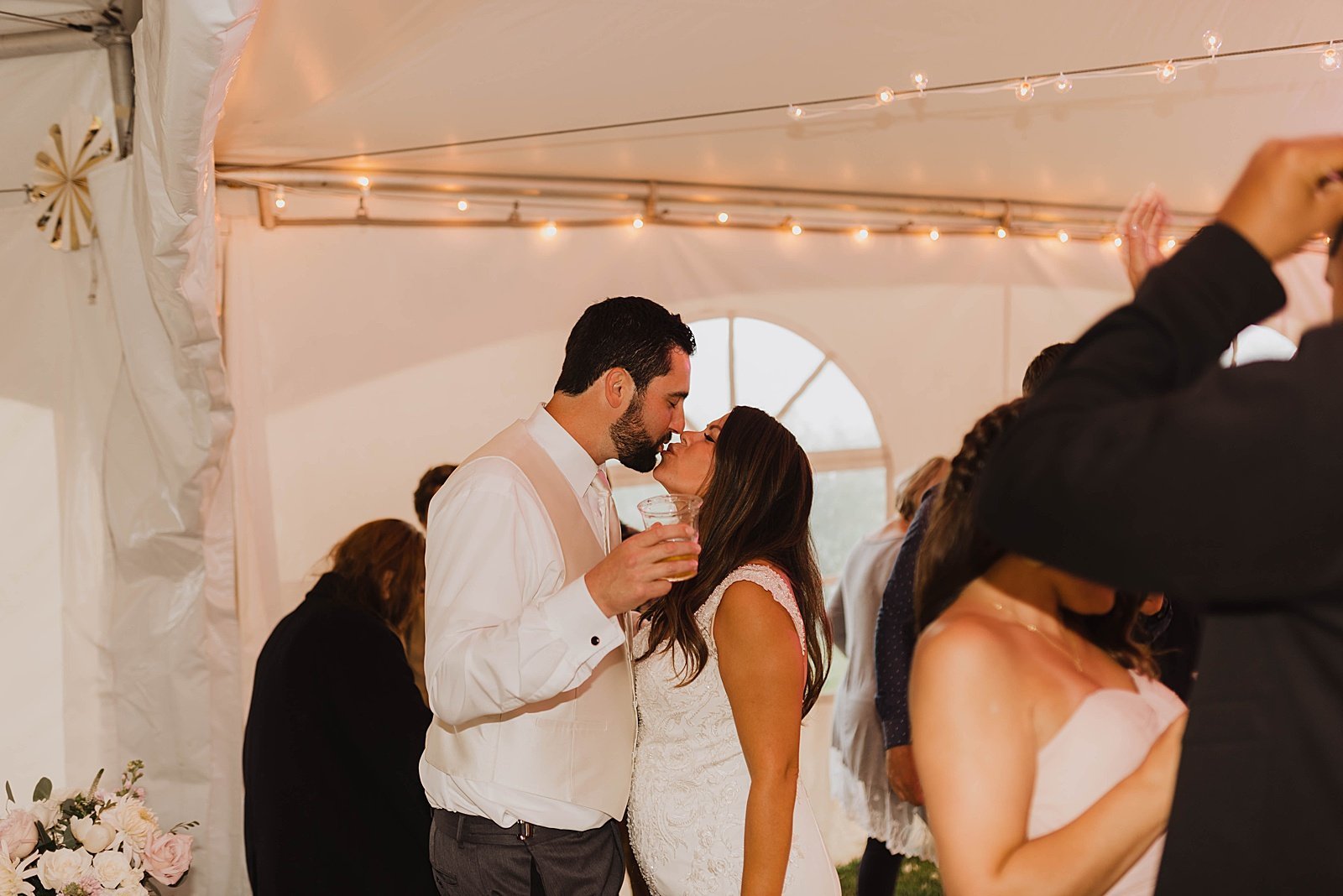  Newlyweds stealing a kiss during their wedding reception  
