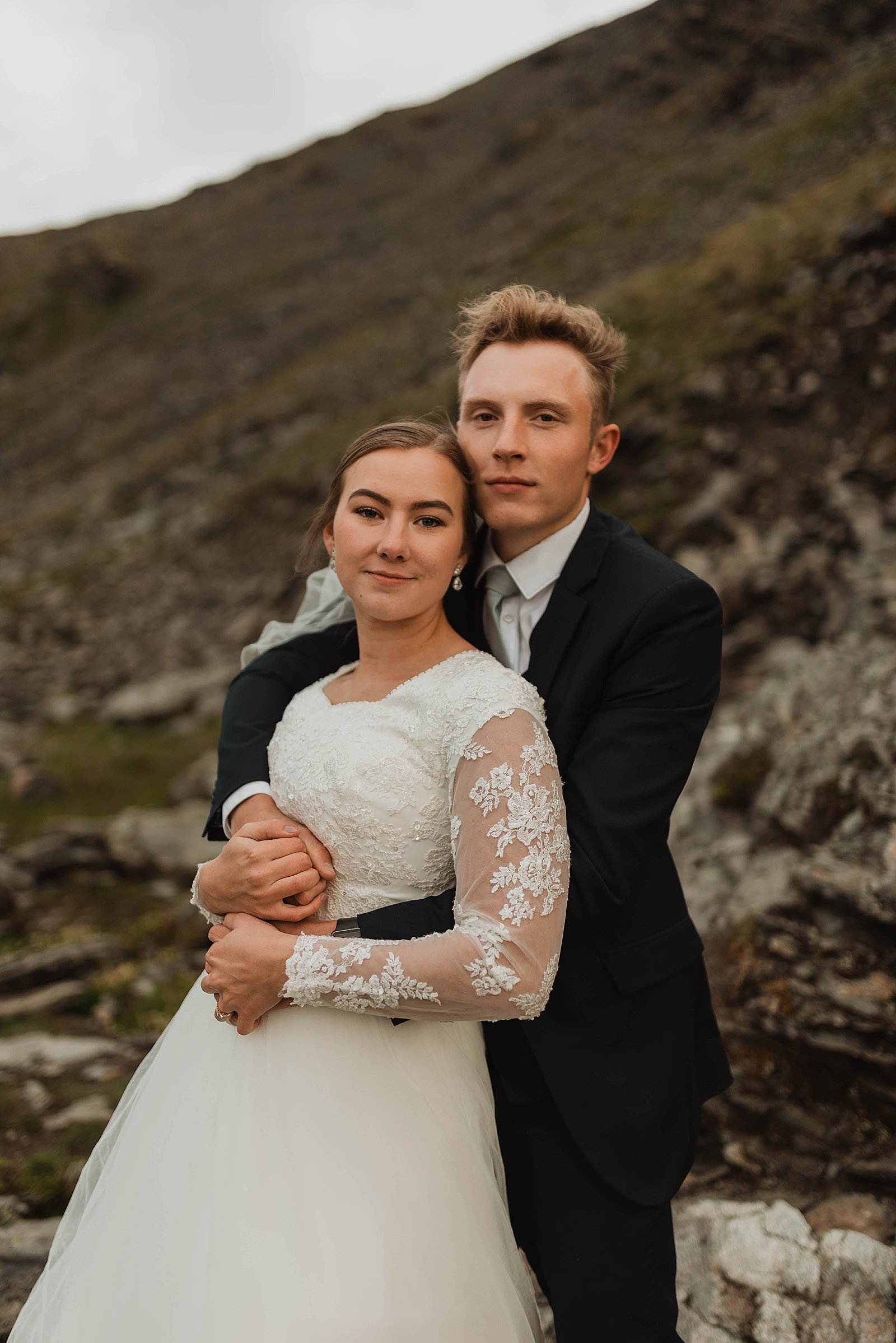  Groom wrapping up bride in front of Hatcher Pass for a couple shoot 