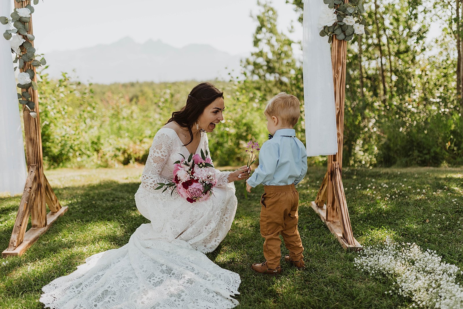 Bride greeting toddler boy guest by photographer, Theresa McDonald.  