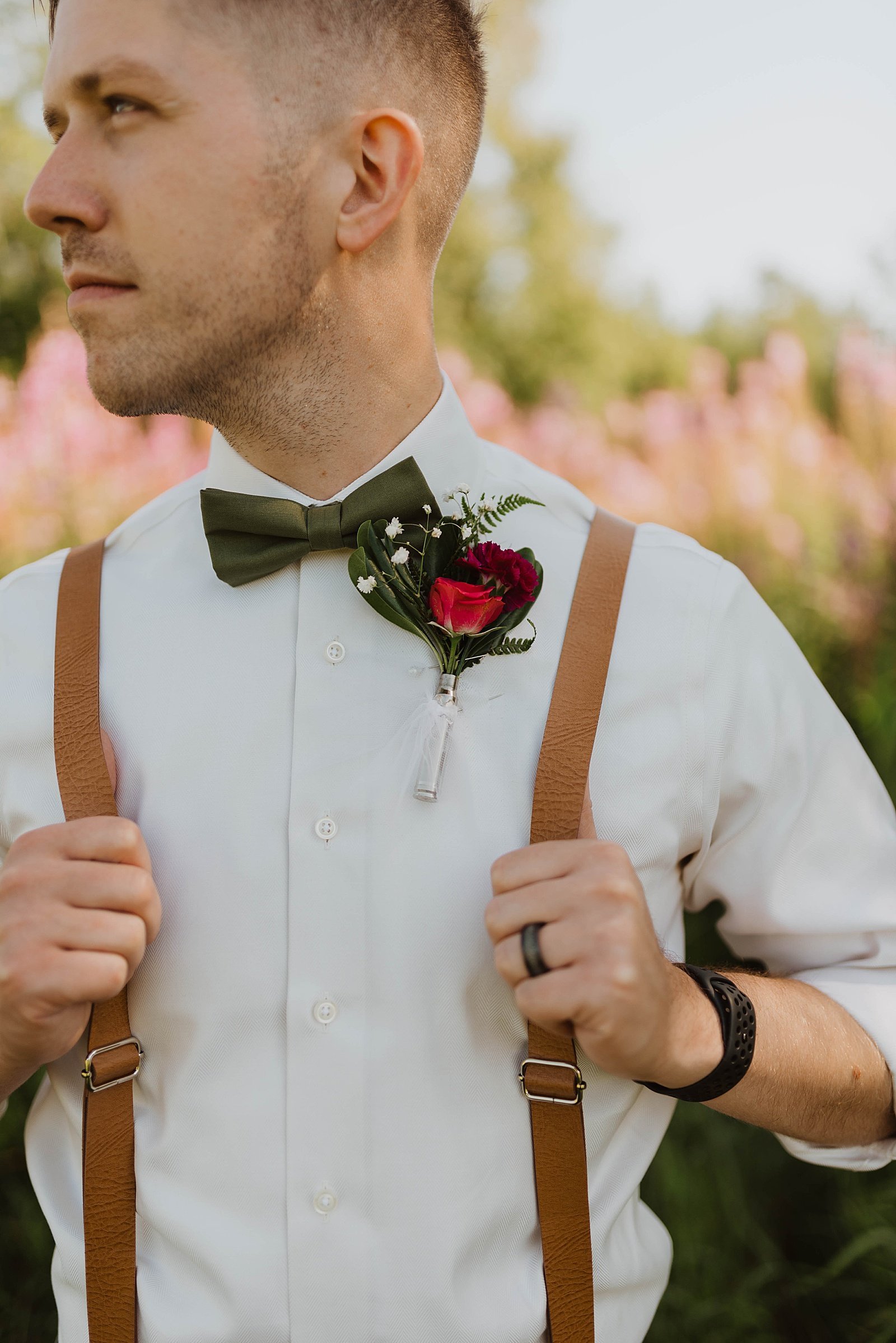  Groom holding his suspenders and looking off into the distance.  
