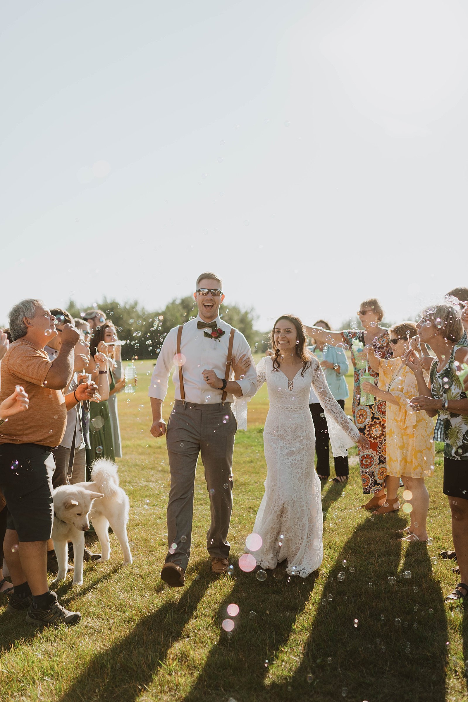  Bride and groom exit as friends blow bubbles to celebrate them  