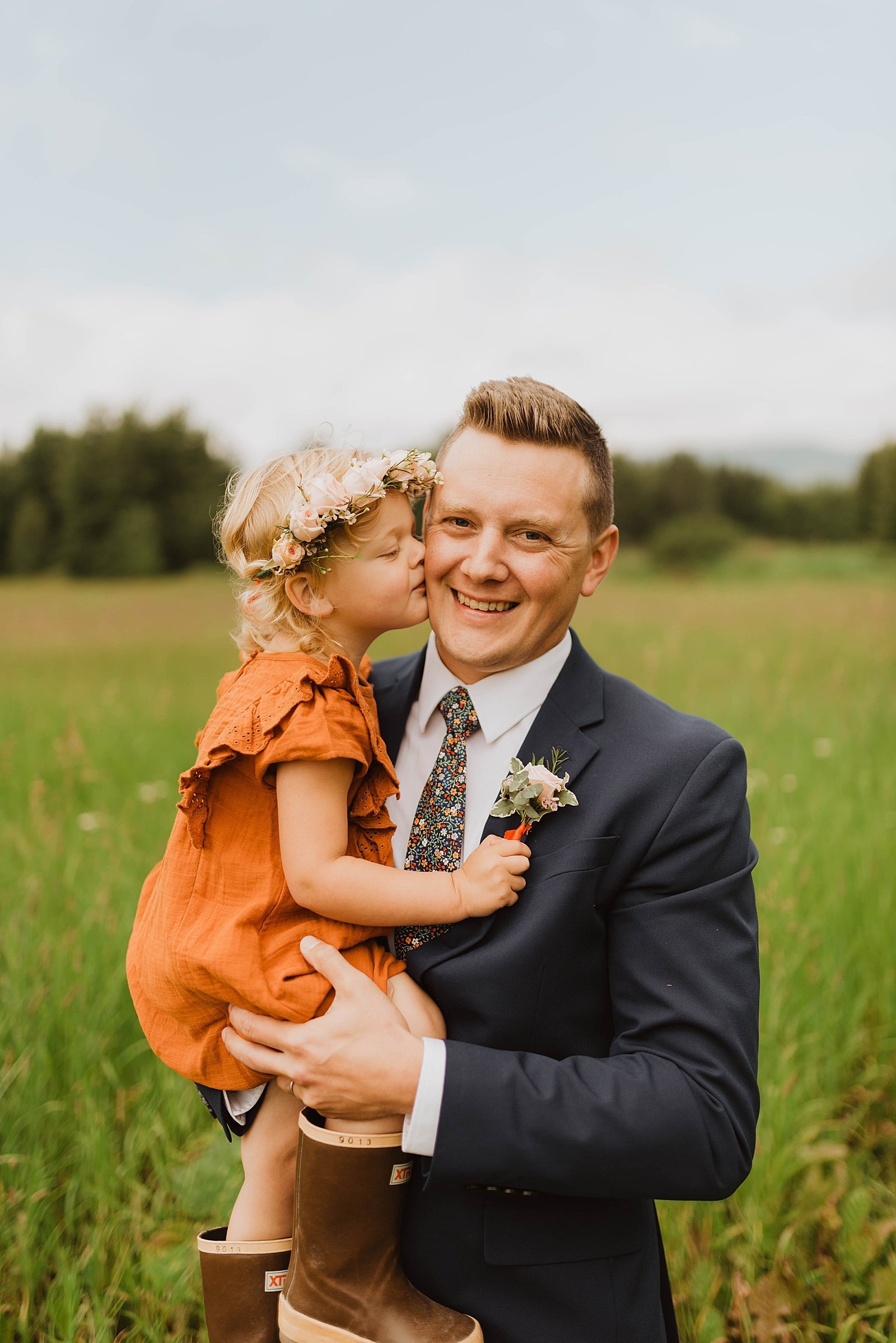  Groom getting kiss from his small daughter in an orange dress.  