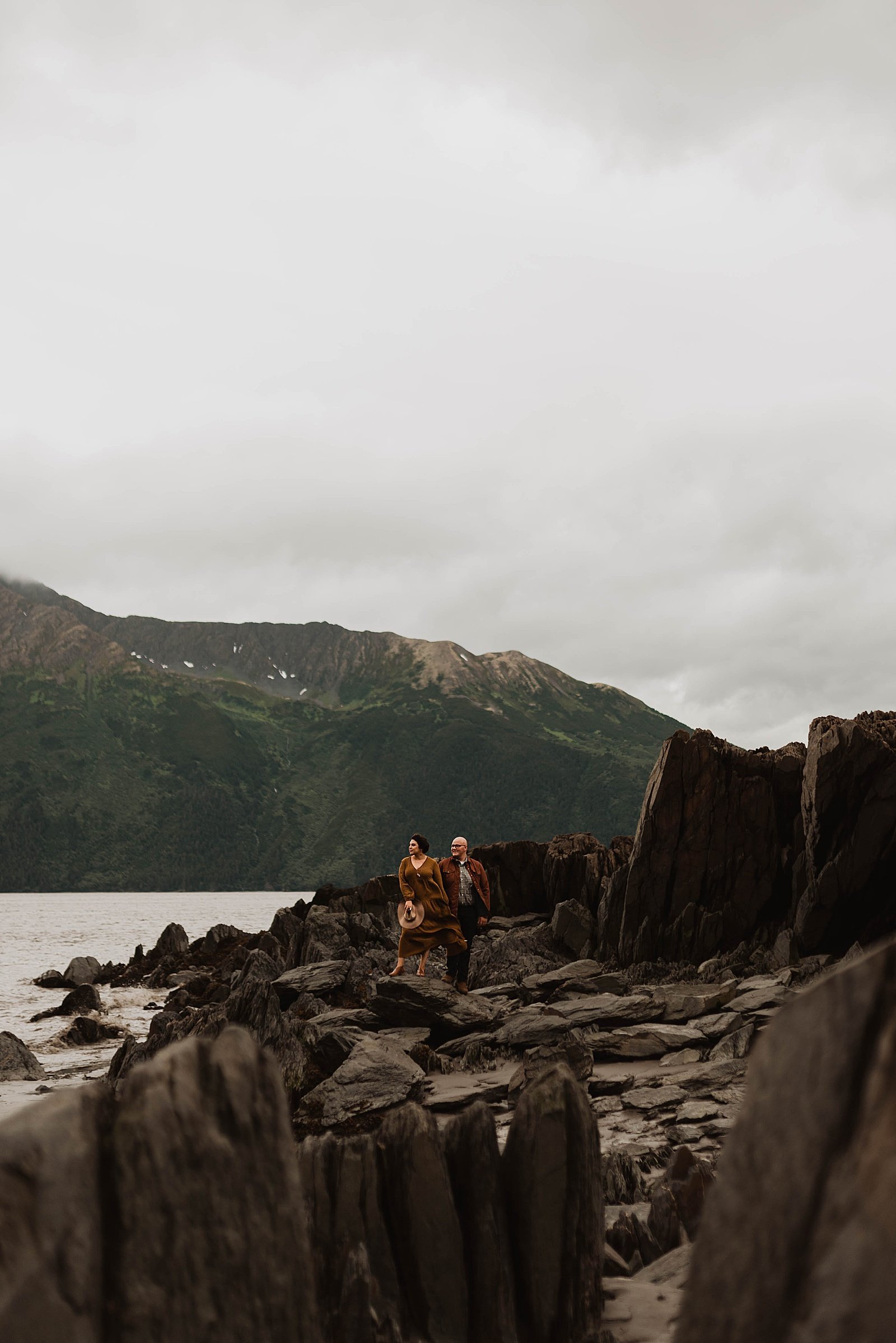  Couple standing on the shore of a mountain lake near Anchorage for a photo shoot.  