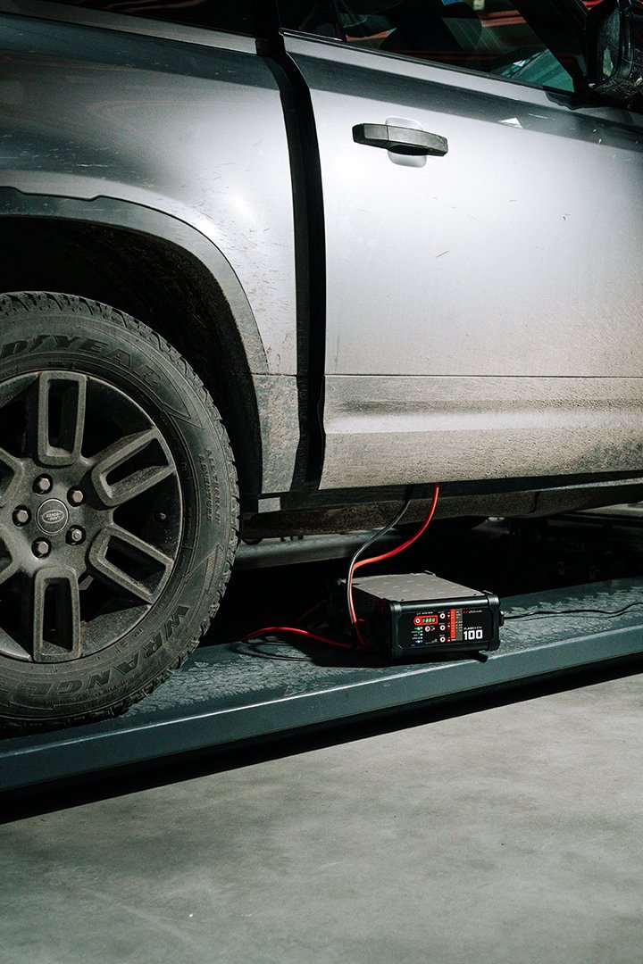 A silver car on a testing platform connected to a diagnostic or performance device with wires.