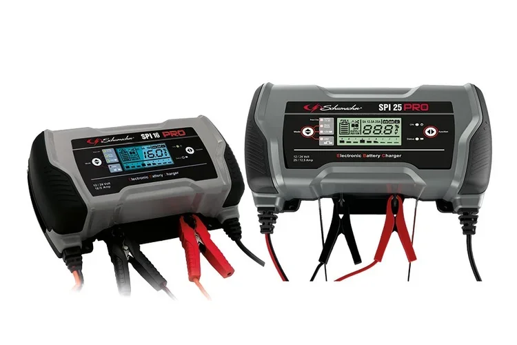 Two electronic battery chargers with digital displays and red and black cables, used for charging batteries.