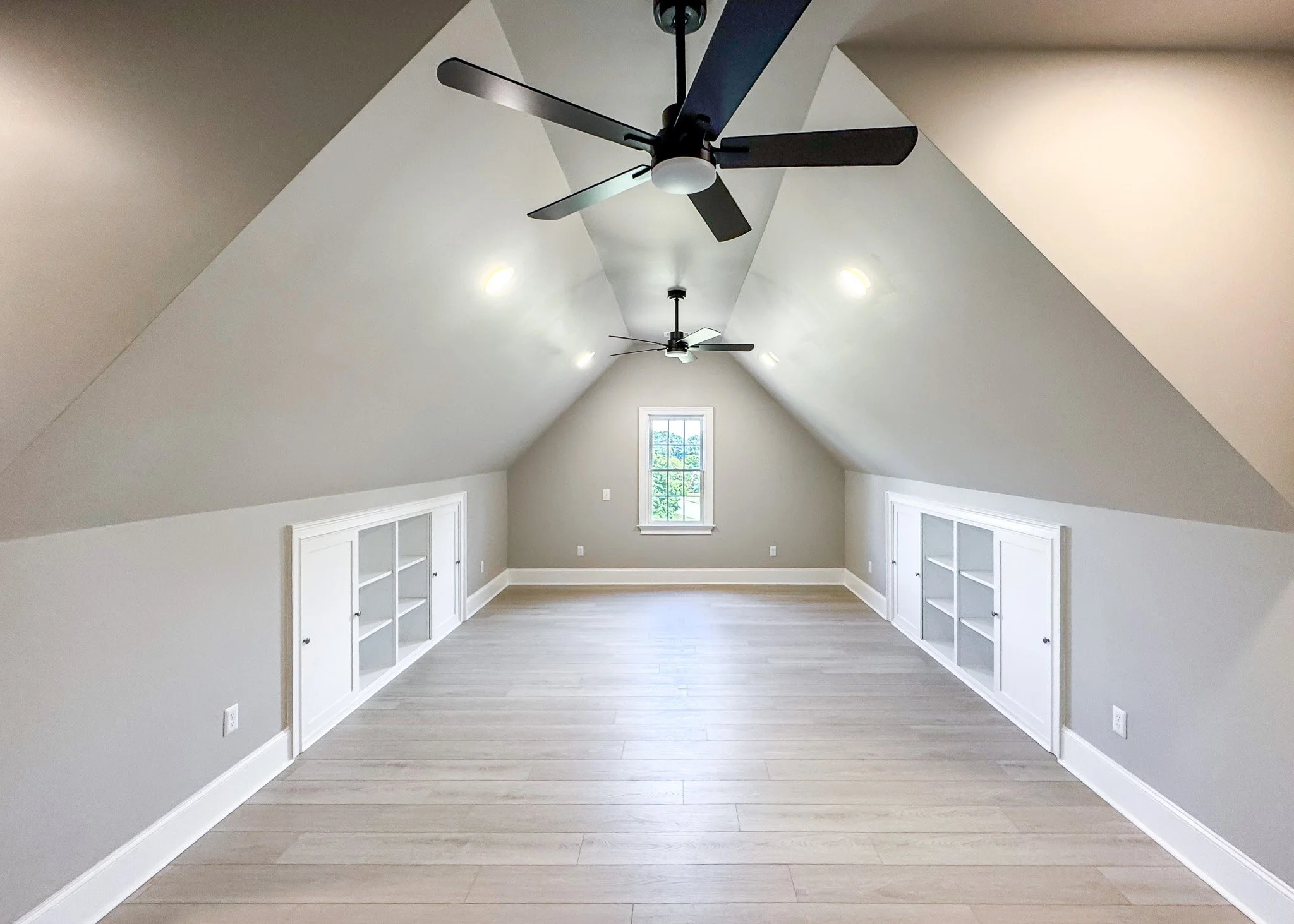 Attic build-out in drywall stage with sloped ceilings and knee wall framing during renovation in Fuquay-Varina NC