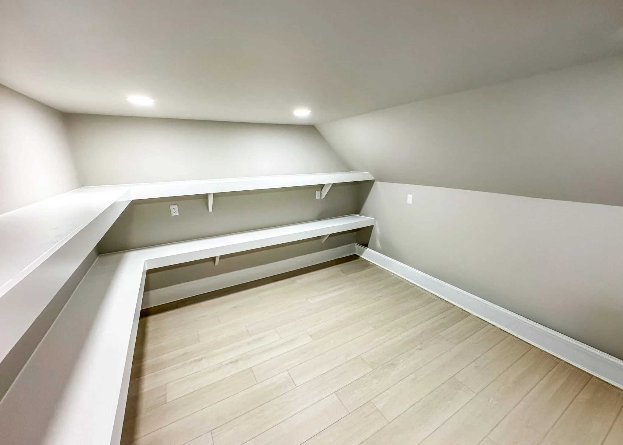 Custom attic closet with built-in shelving and drawers, maximizing storage within sloped ceiling space during this attic build-out in Garner, NC.