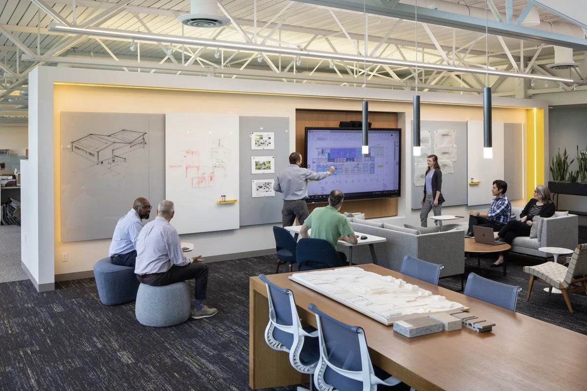 Lobby remodel by Pivotal featuring architectural cove, glass, and slot details, interior pendant and recessed wall lighting, wall wash illumination, accent lighting, and uplighting. 