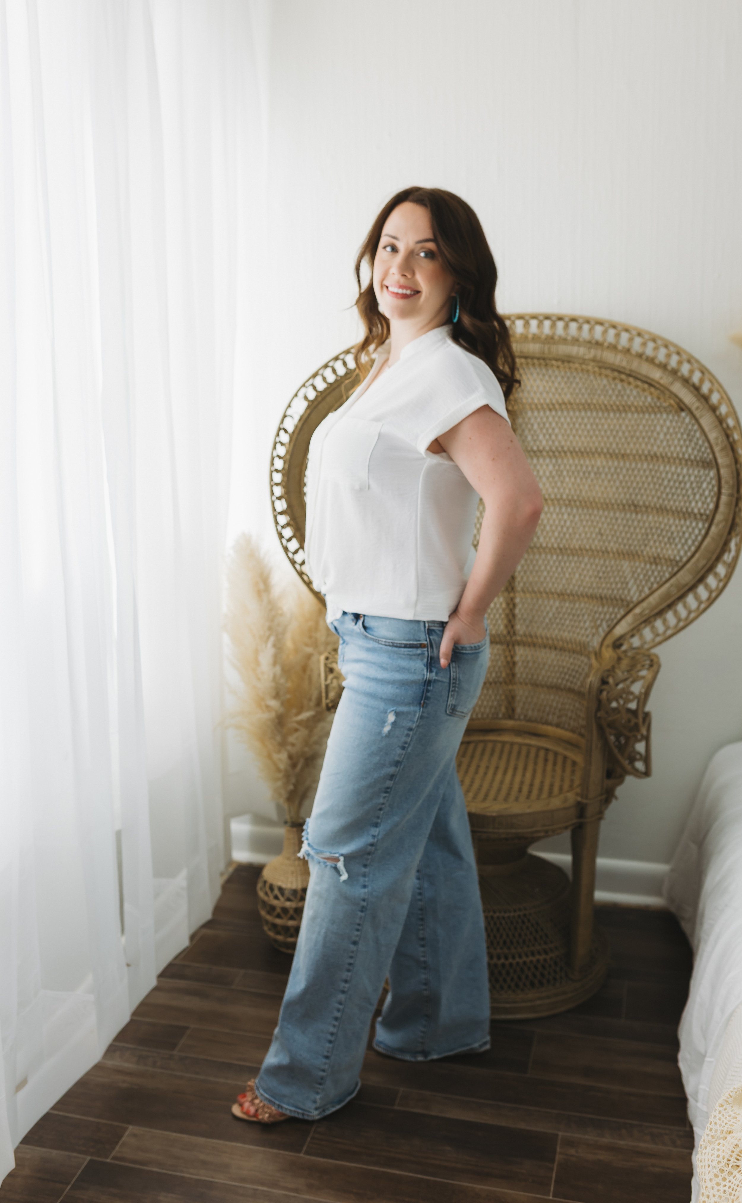 Digital marketing for photography specialist Amanda the Assistant wears jeans & a white blouse during a studio photoshoot