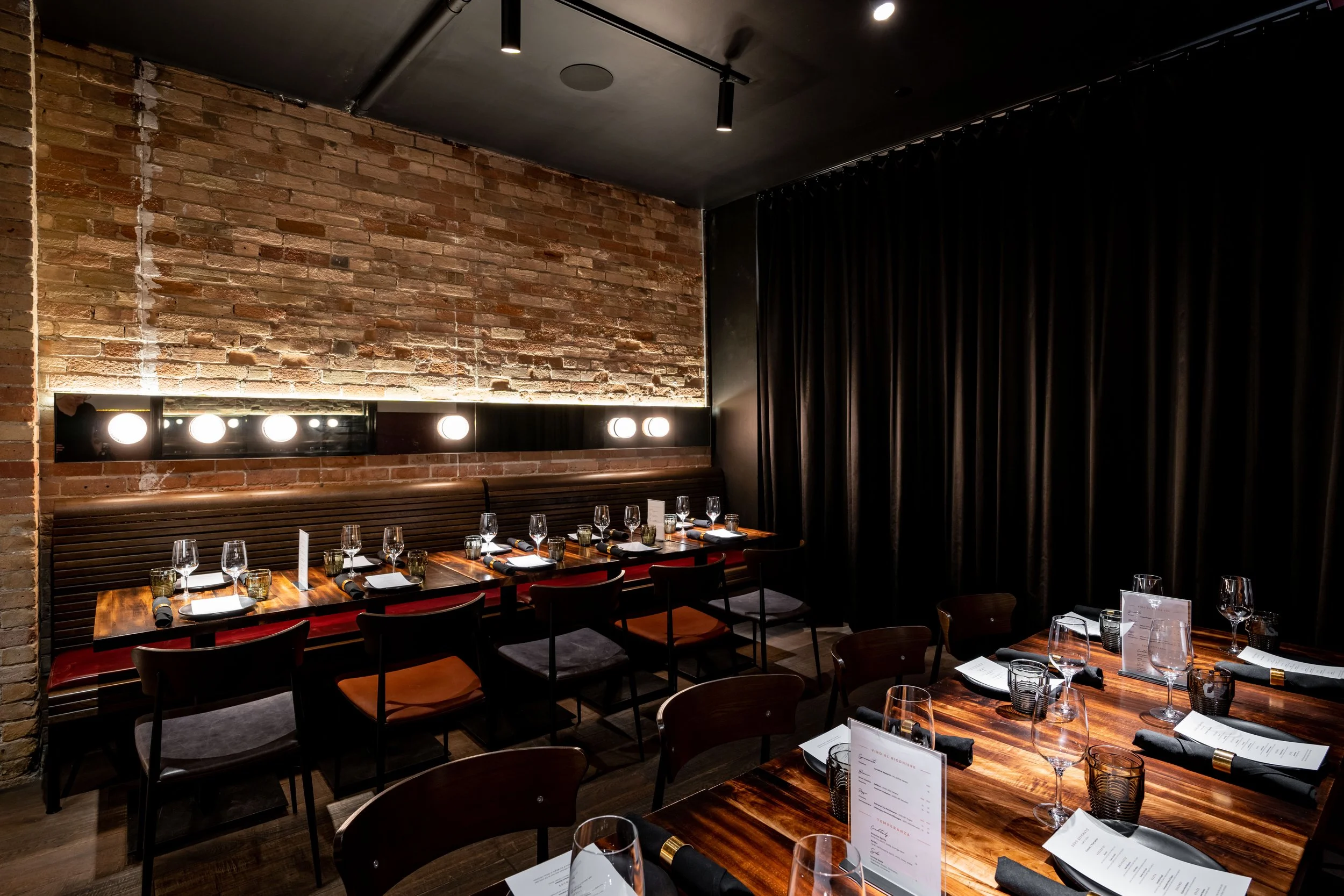 a private area set with group menus for a large dinner party.