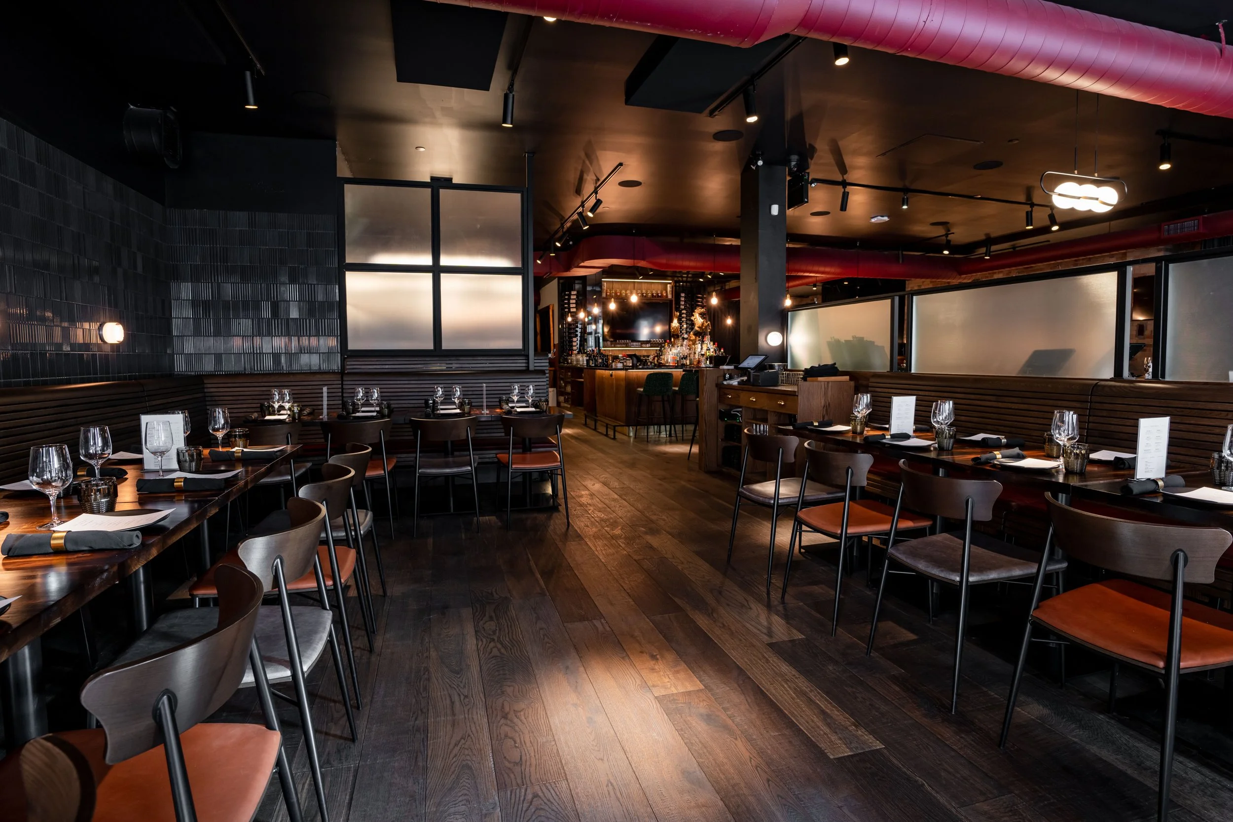 a semi private area of a restaurant set for a large either corporate or social group dinner.