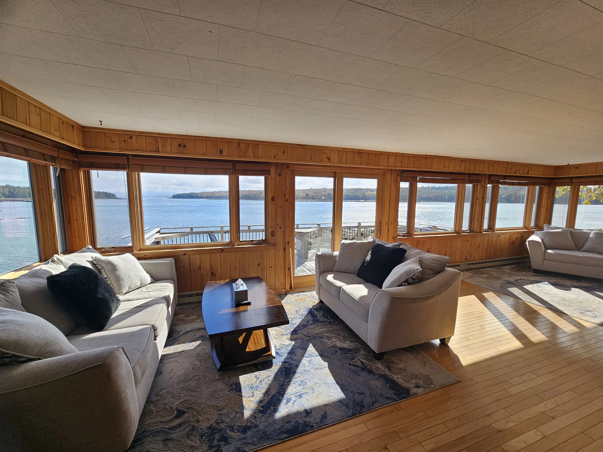 Sunlit seating room with windows overlooking the water at The Foggy Pearl.