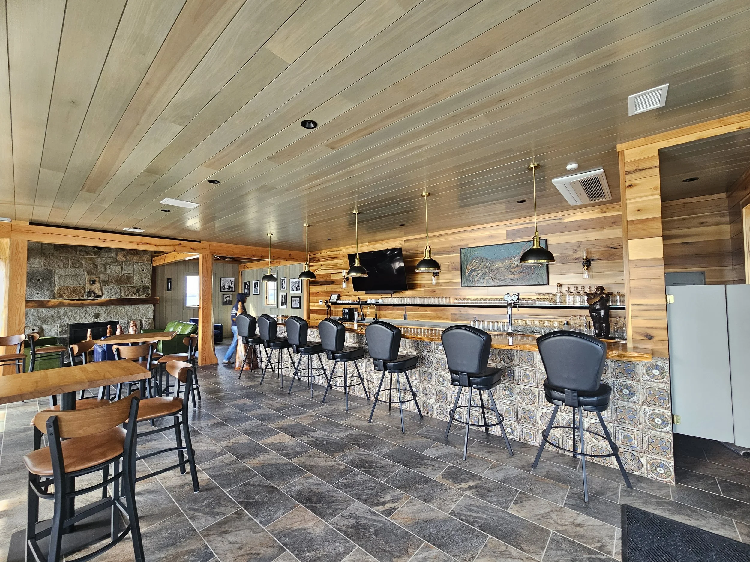 Interior bar area with stools and a wood ceiling at The Foggy Pearl.