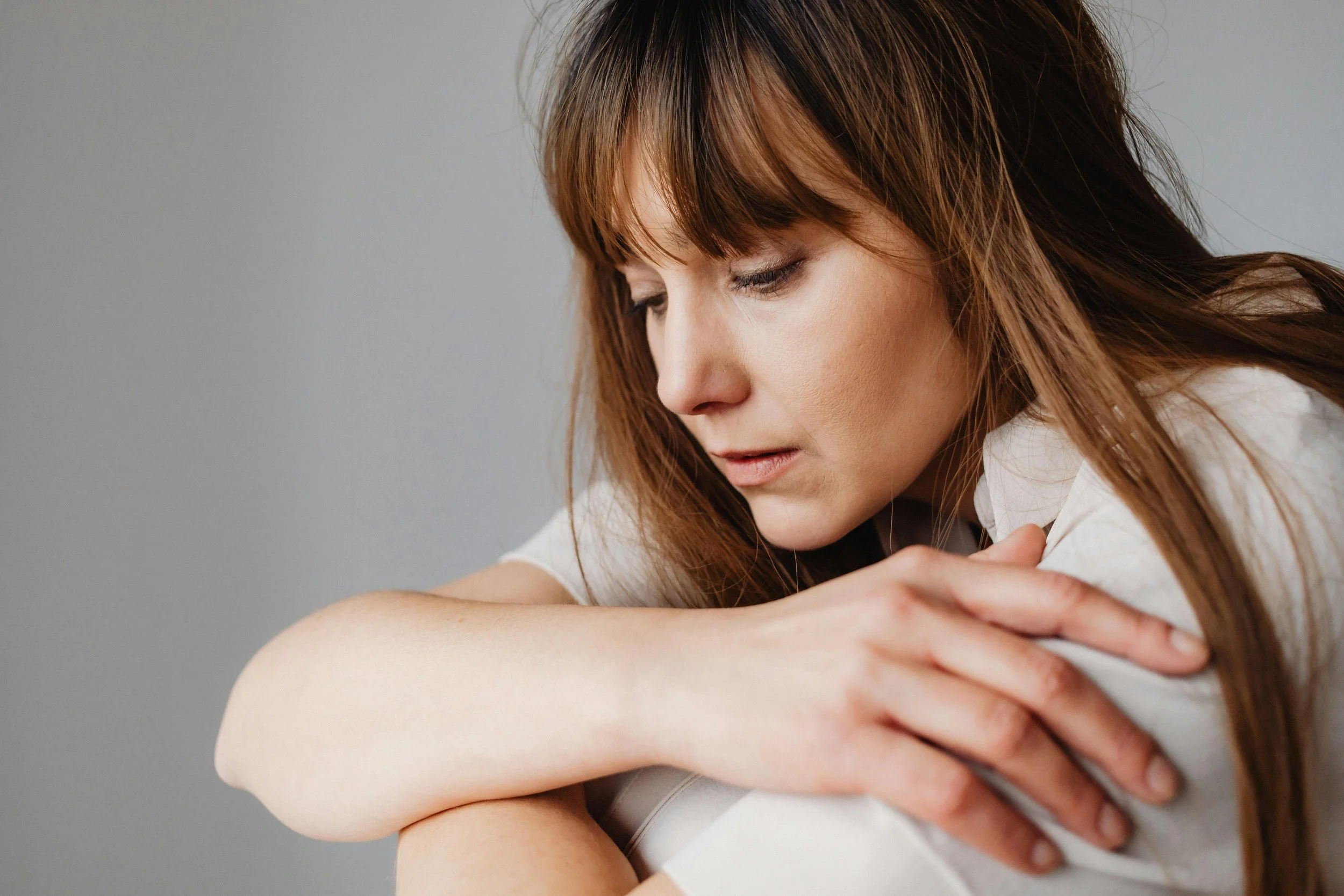 a woman hugging herself, showing no emotions