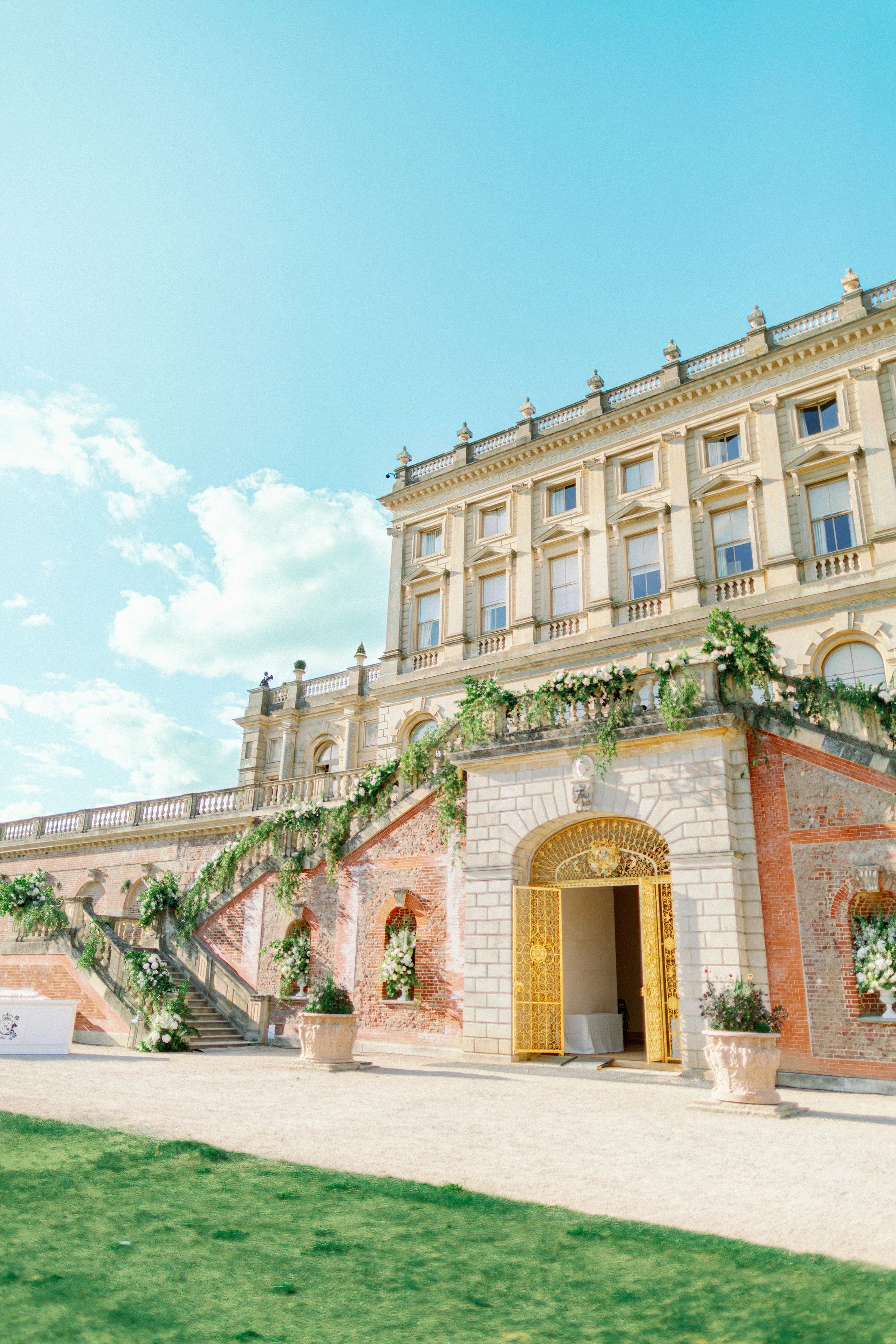Sunlit historic terrace with stone architecture and cascading greenery, softened by floral details that enhance the grandeur of the setting.