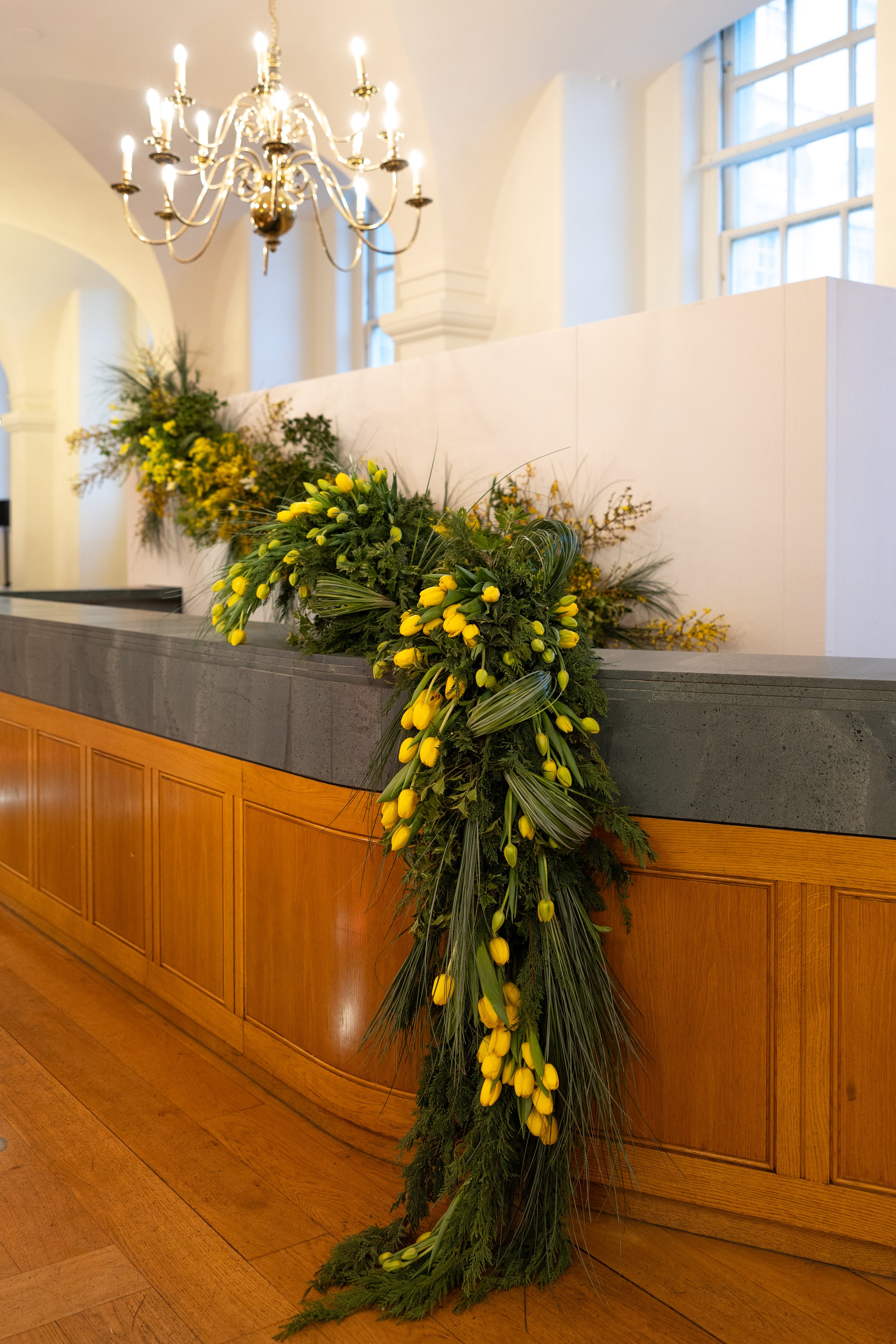 Close-up of seasonal spring florals cascading across the bar in the Queen Mary Undercroft