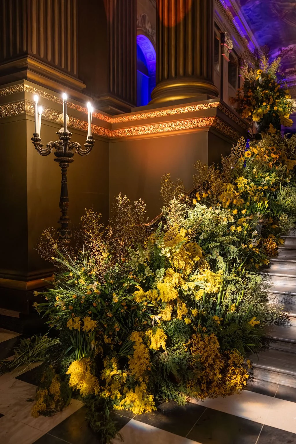 Cascading mimosa and spring florals lining the staircase within the Painted Hall at the Old Royal Naval College