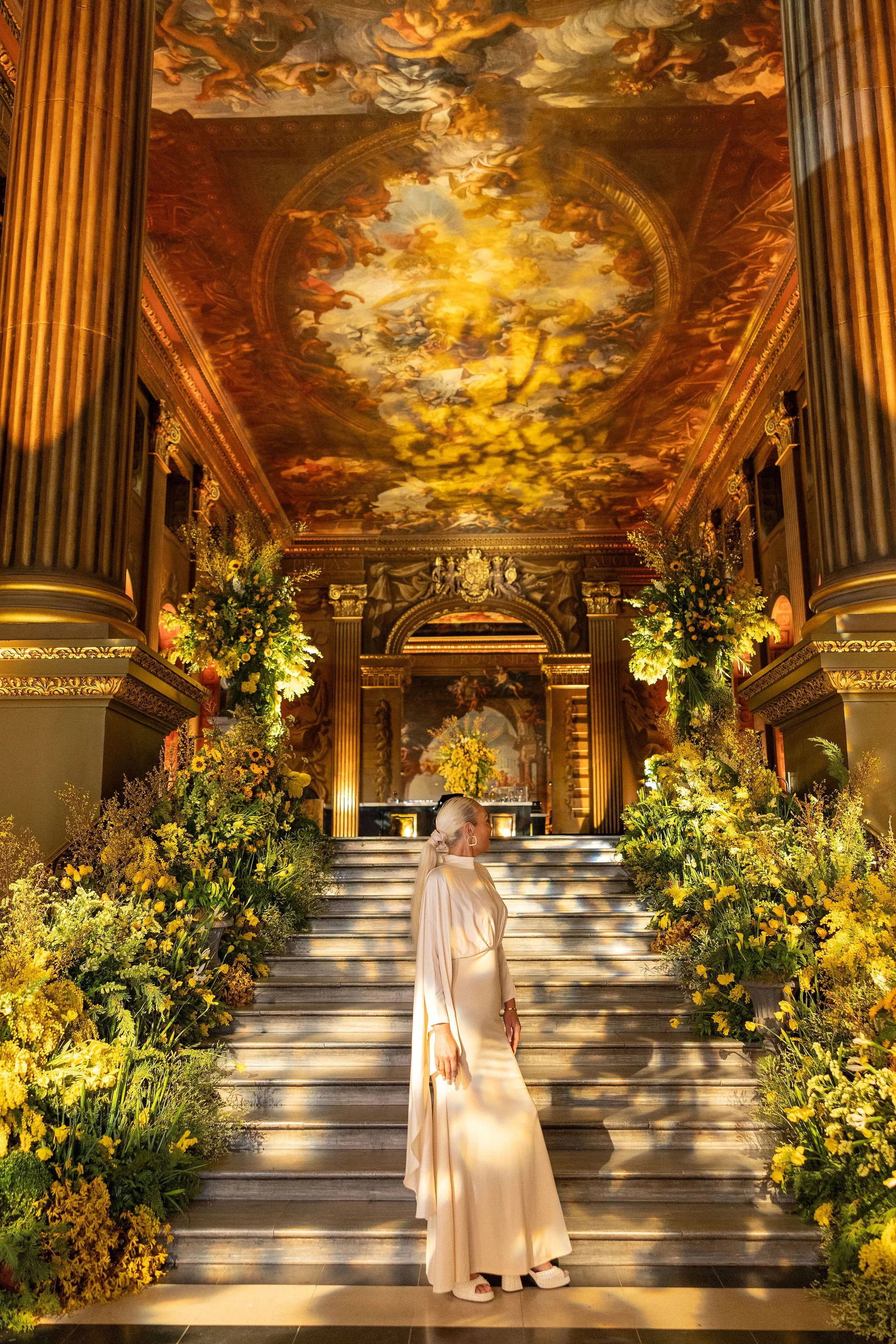 Amie Bone standing on the mimosa-lined staircase during the Old Royal Naval College spring showcase