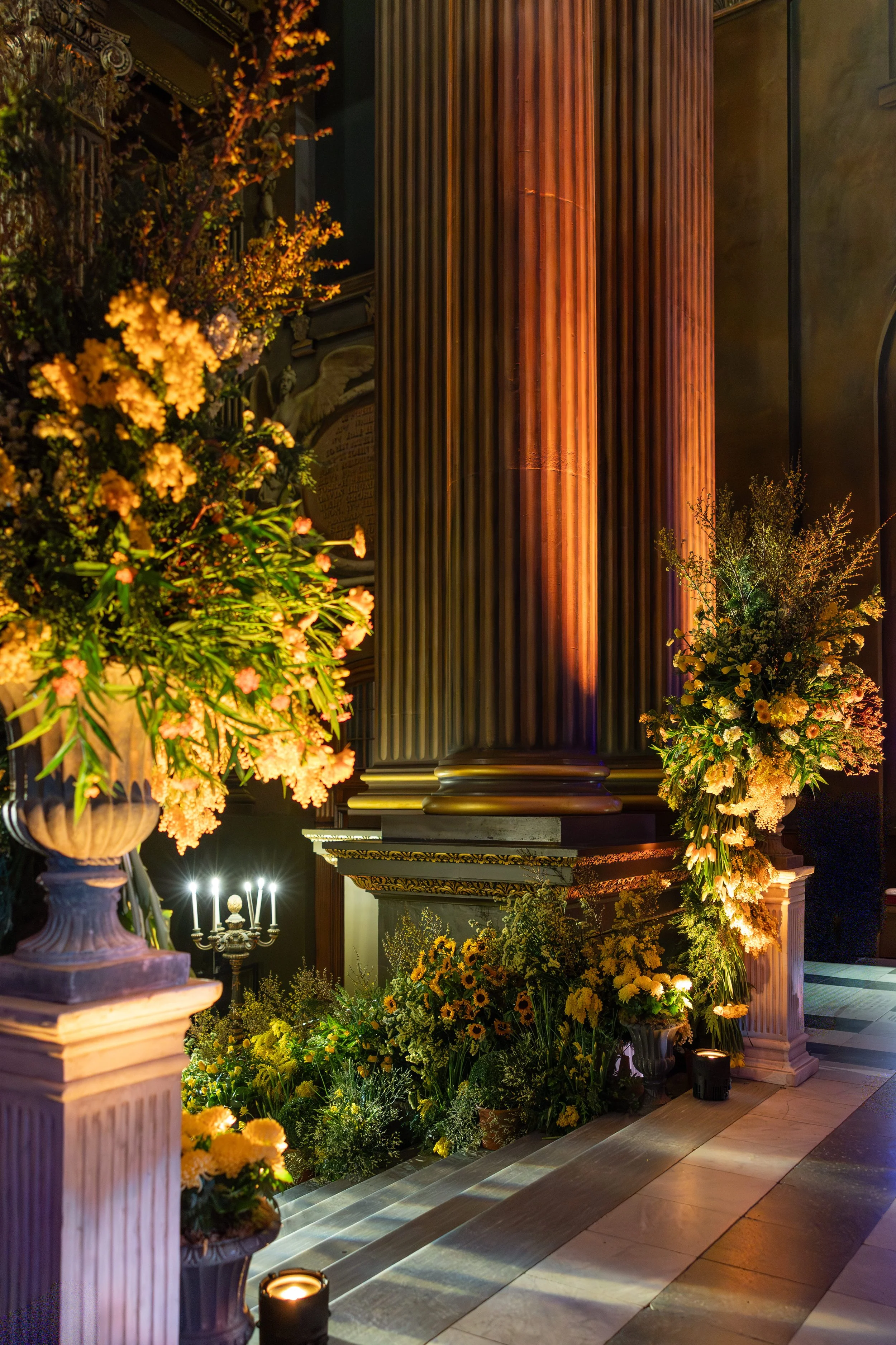 Close-up of a monumental urn arrangement featuring mimosa and seasonal spring florals in the Painted Hall