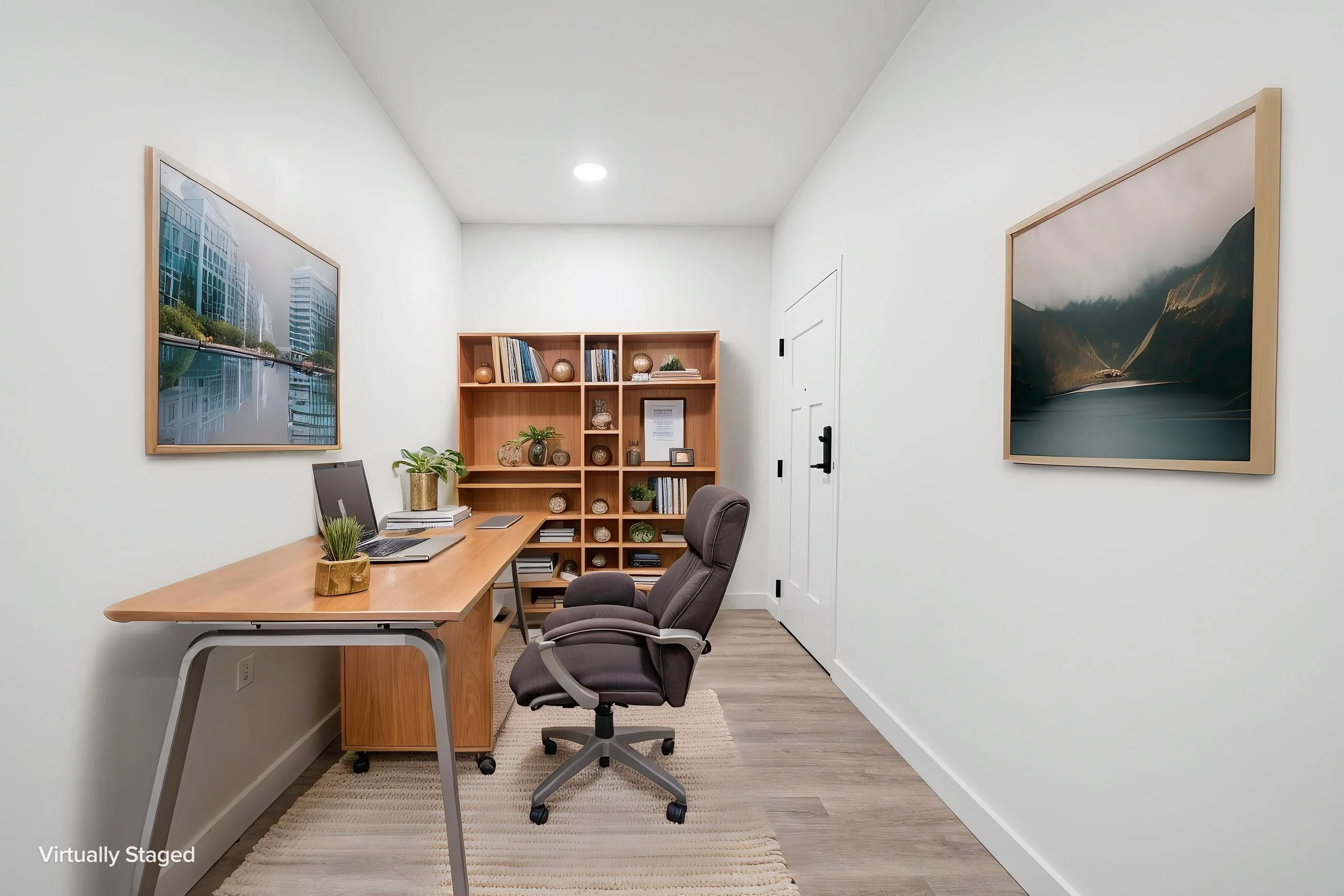 Home office with white walls, wooden desk, gray office chairs, bookshelf with decor, and framed artwork of cityscape and mountains. The Residences at North Harbor on Lake Superior in Marquette Michigan.