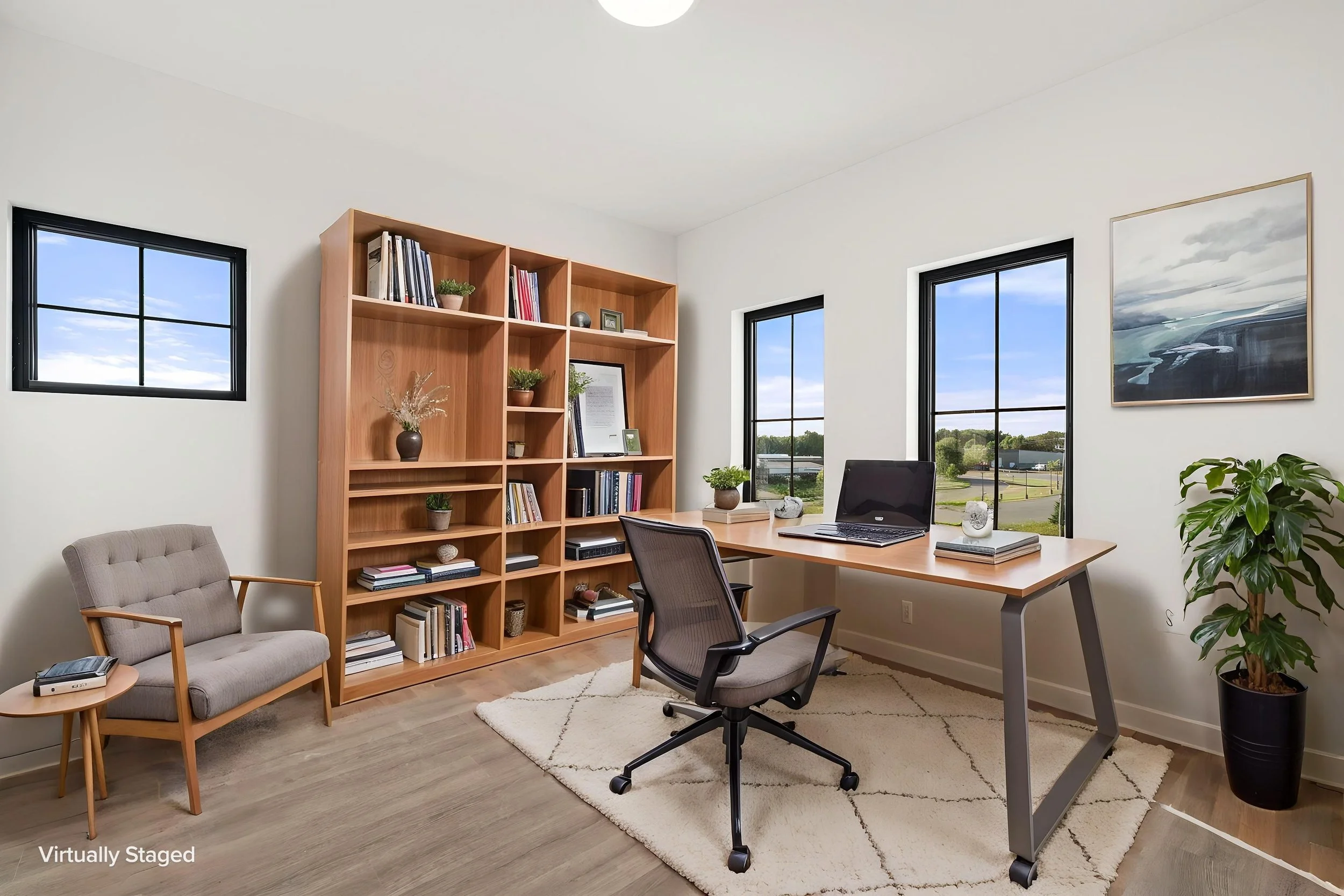 A modern home office with large windows, a wooden bookshelf filled with books and decorative items. The Residences at North Harbor on Lake Superior in Marquette Michigan.