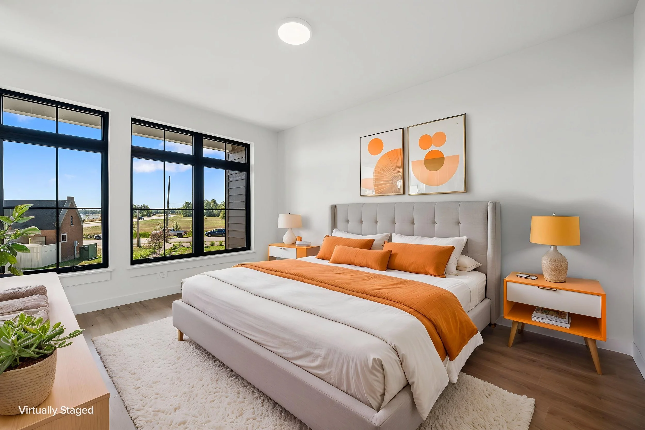 A bright, modern bedroom with large windows showing a sunny outdoor scene. The Residences at North Harbor on Lake Superior in Marquette Michigan.