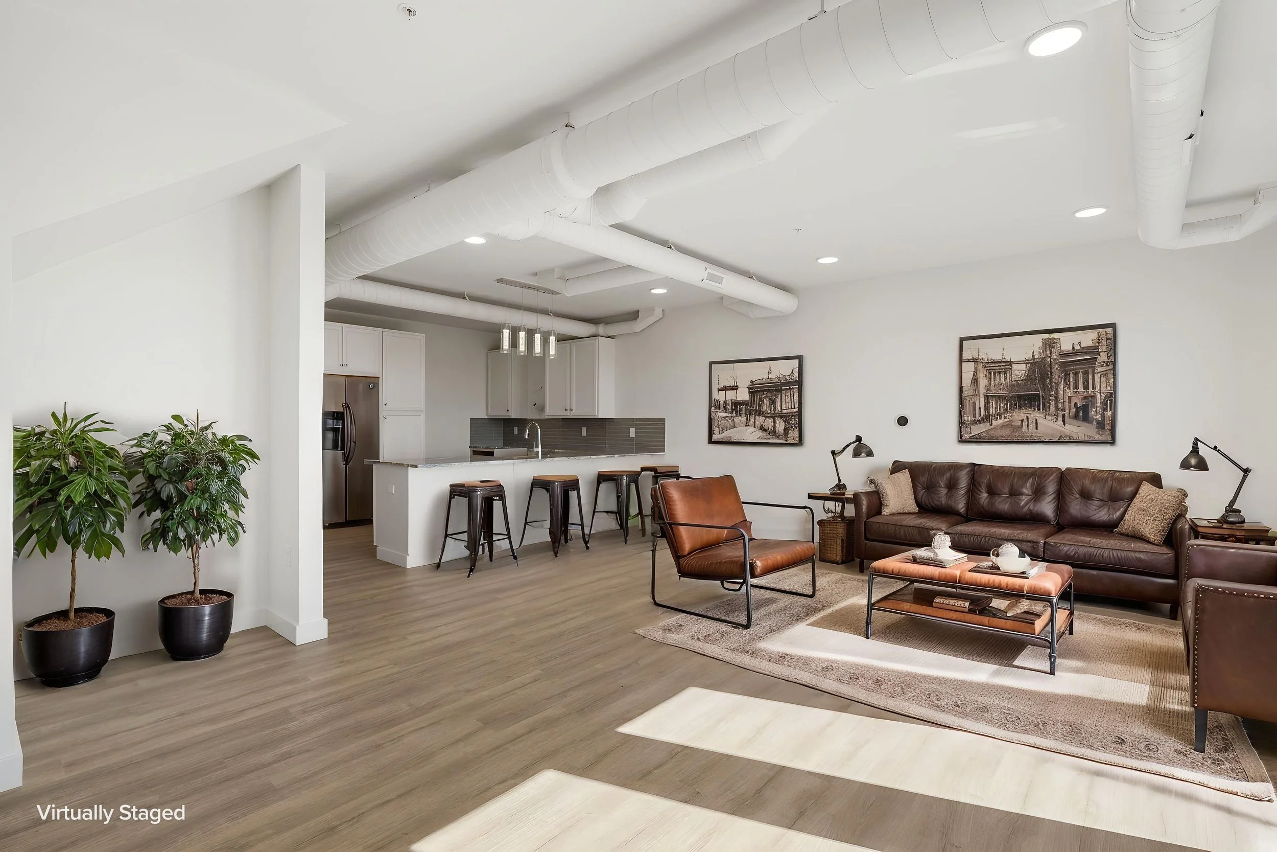 A modern living room with a white ceiling featuring large air ducts and recessed lighting. The Residences at North Harbor on Lake Superior in Marquette Michigan.