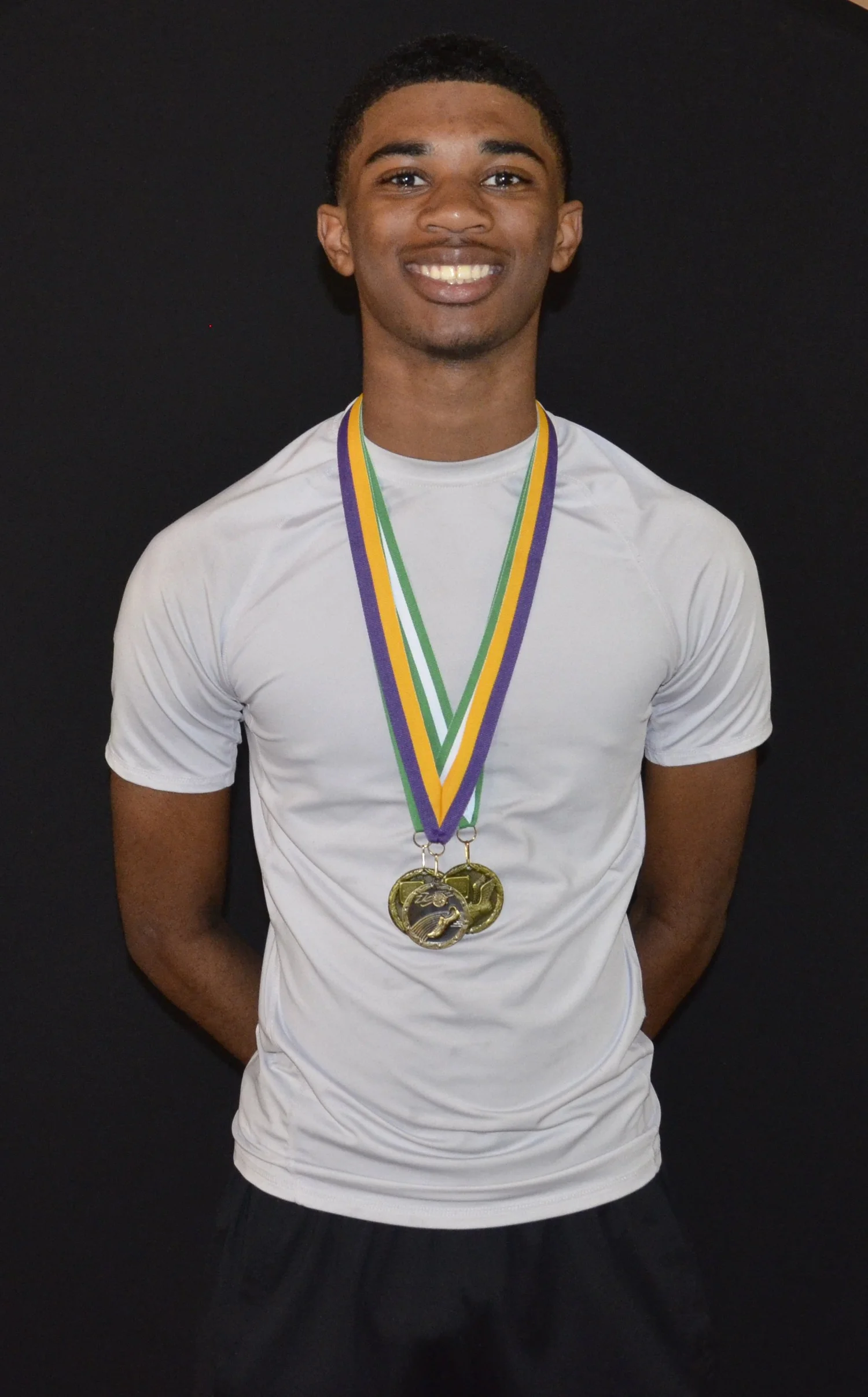 A smiling young athlete wearing medals