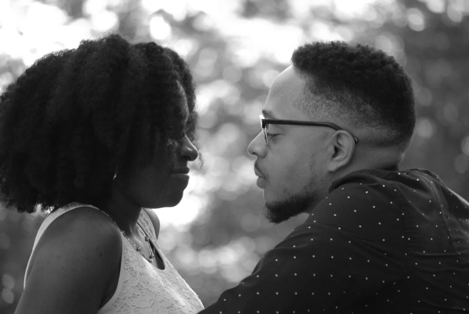 Black and white close-up of a couple sharing a quiet moment