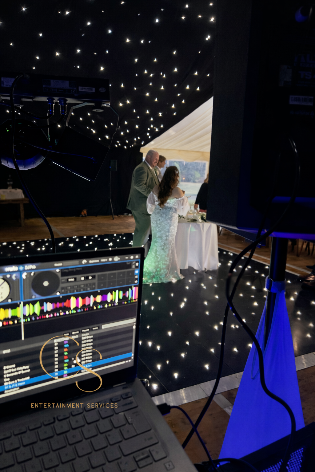 Bride and groom speech at wedding reception with DJ and backdrop