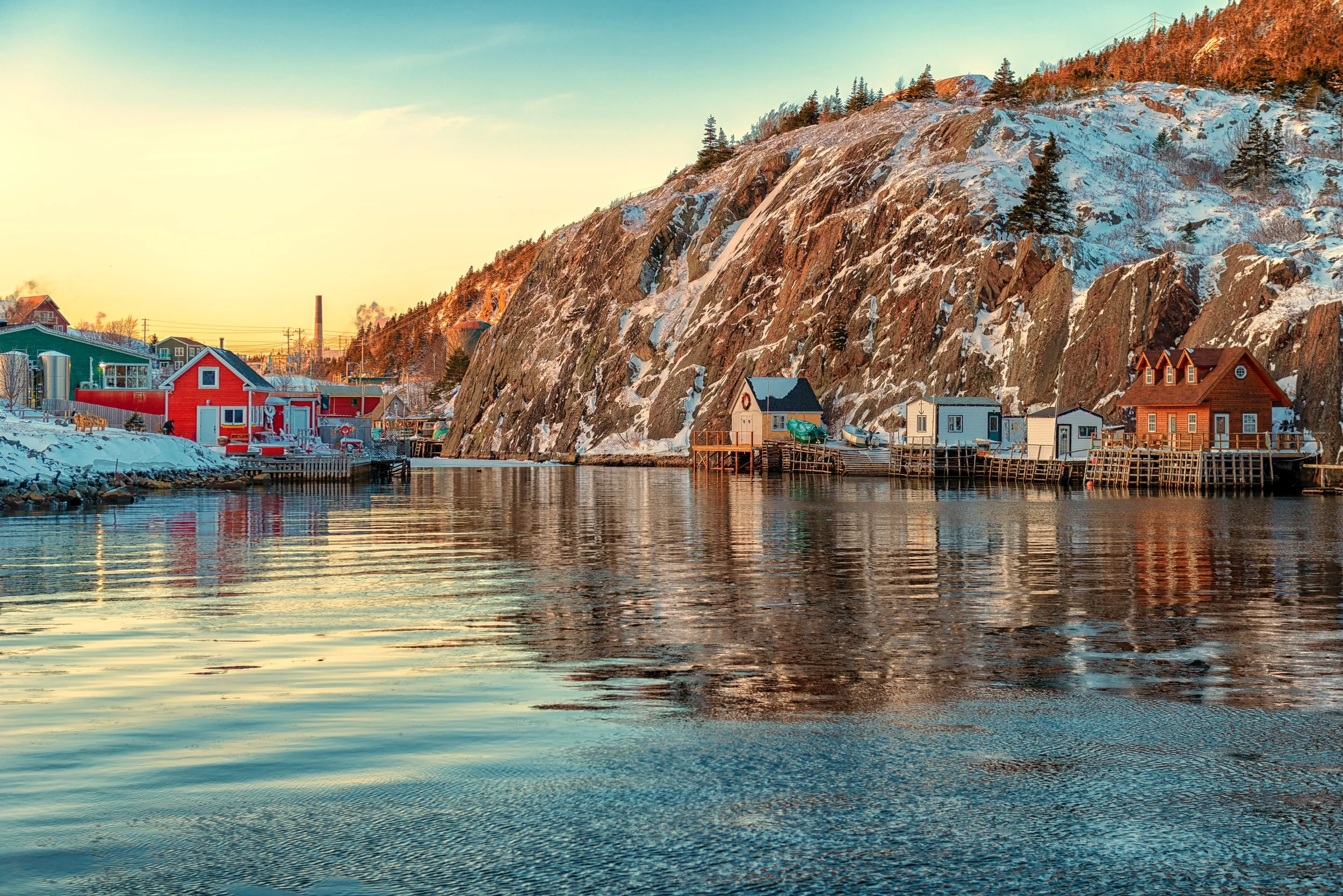 Mallard Inn, Scenic St. John’s, Newfoundland harbour with colourful waterfront houses, calm water, and rugged cliffs, showcasing the city’s coastal charm.